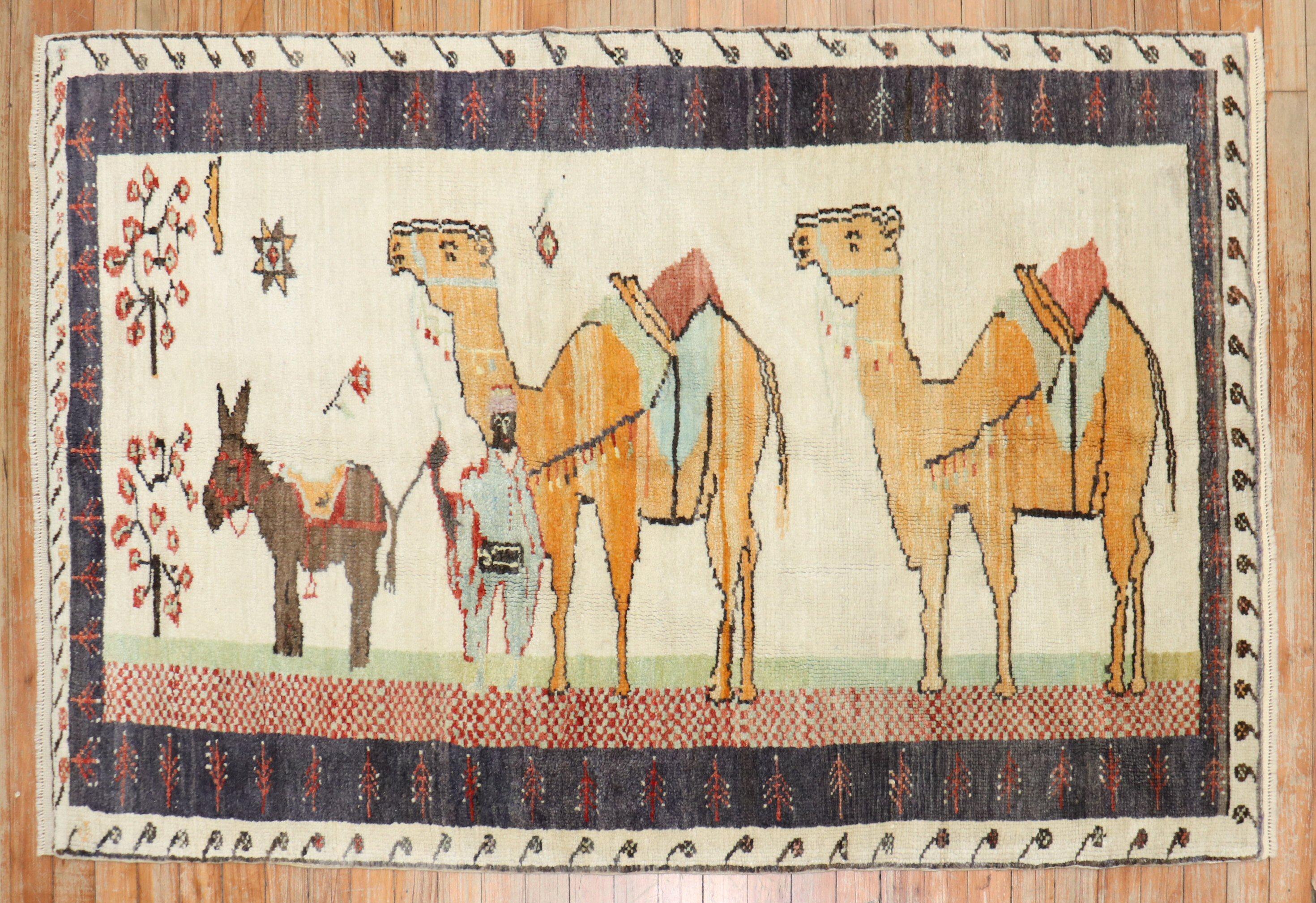 Mid-20th century colrufl Turkish rug depicting camel and donkeys on an ivory ground.

Size: 3'5'' x 5'3''.