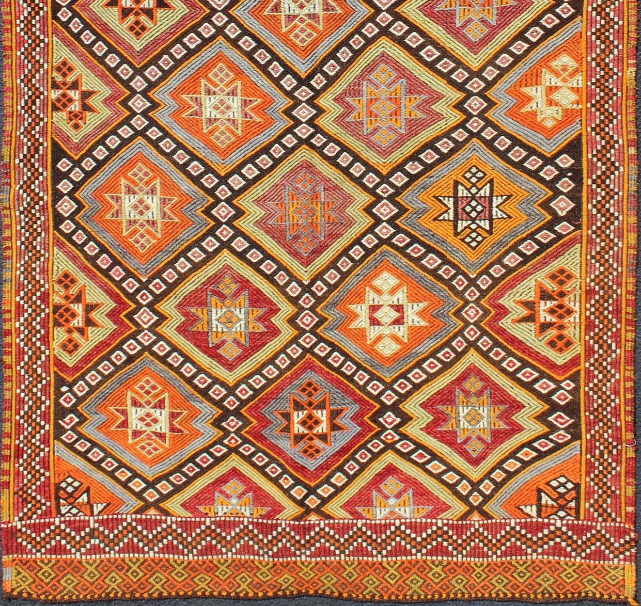 Colorful Vintage Turkish Flat-Weave Tribal Modern Kilim with Embroideries, rug EN-141146, country of origin / type: Turkey / Kilim, circa mid-20th Century.

Measures: 4'0'' x 8'7''

Rendered in diamond shapes with a spotted and speckled