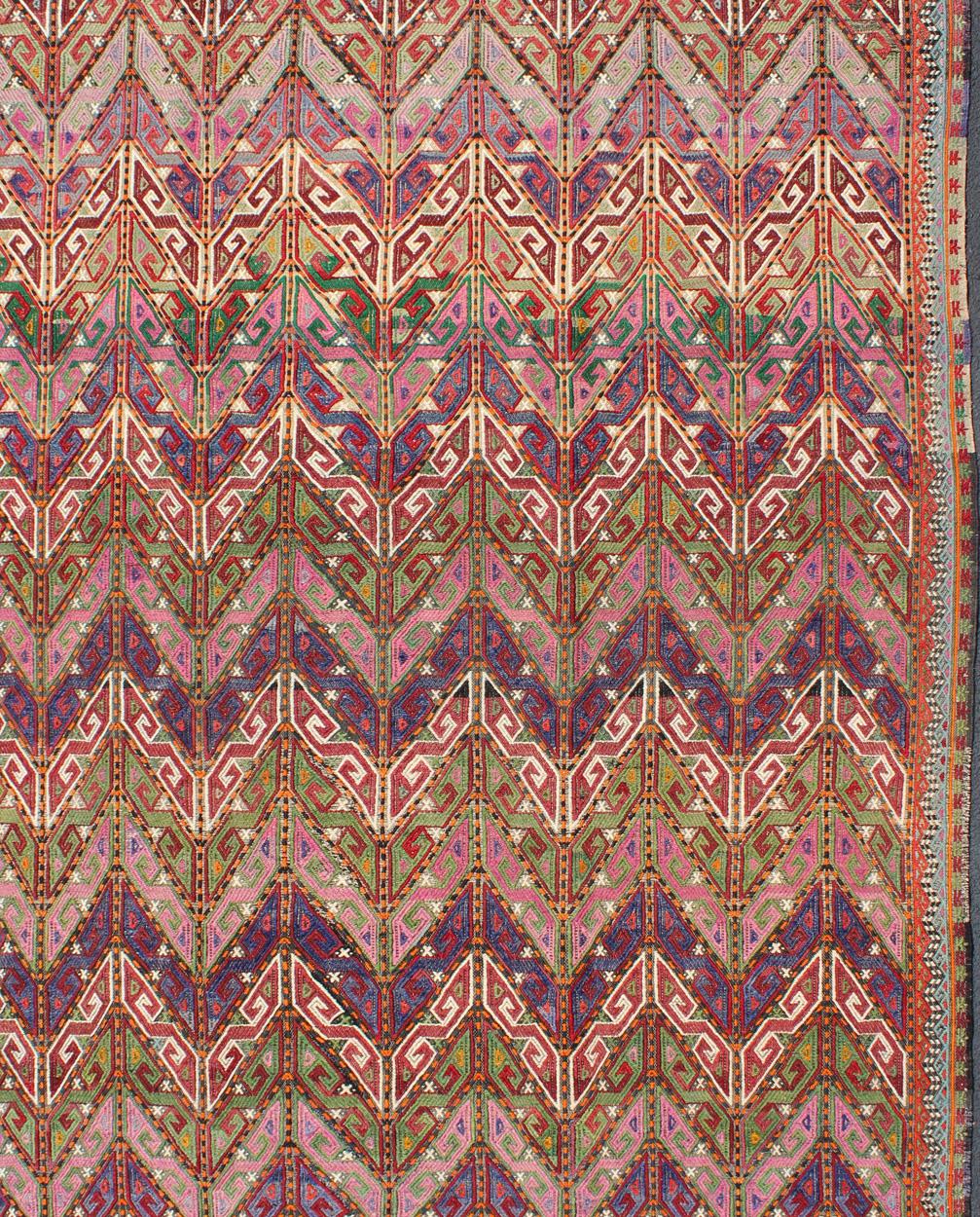 Vintage Turkish flat-weave Tribal Modern kilim with embroideries in multi colors, rug / TU-NED-566.

Rendered in tribal shapes with a spotted and speckled assortment of geometric elements, this unique midcentury vintage Turkish Kilim showcases an