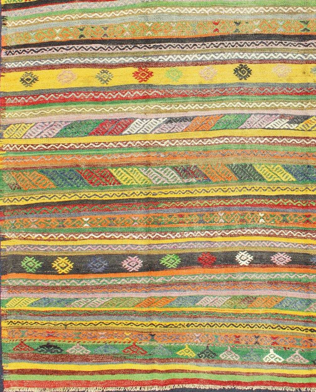 Dieser aufregende und farbenfrohe gestreifte Vintage-Kilim aus der Türkei der 1950er Jahre weist eine sehr lebhafte und unerwartete Farbkombination auf, die in verschiedenen Streifen- und Rautenmustern dargestellt ist.
Maße: 6'1 x 9'1.