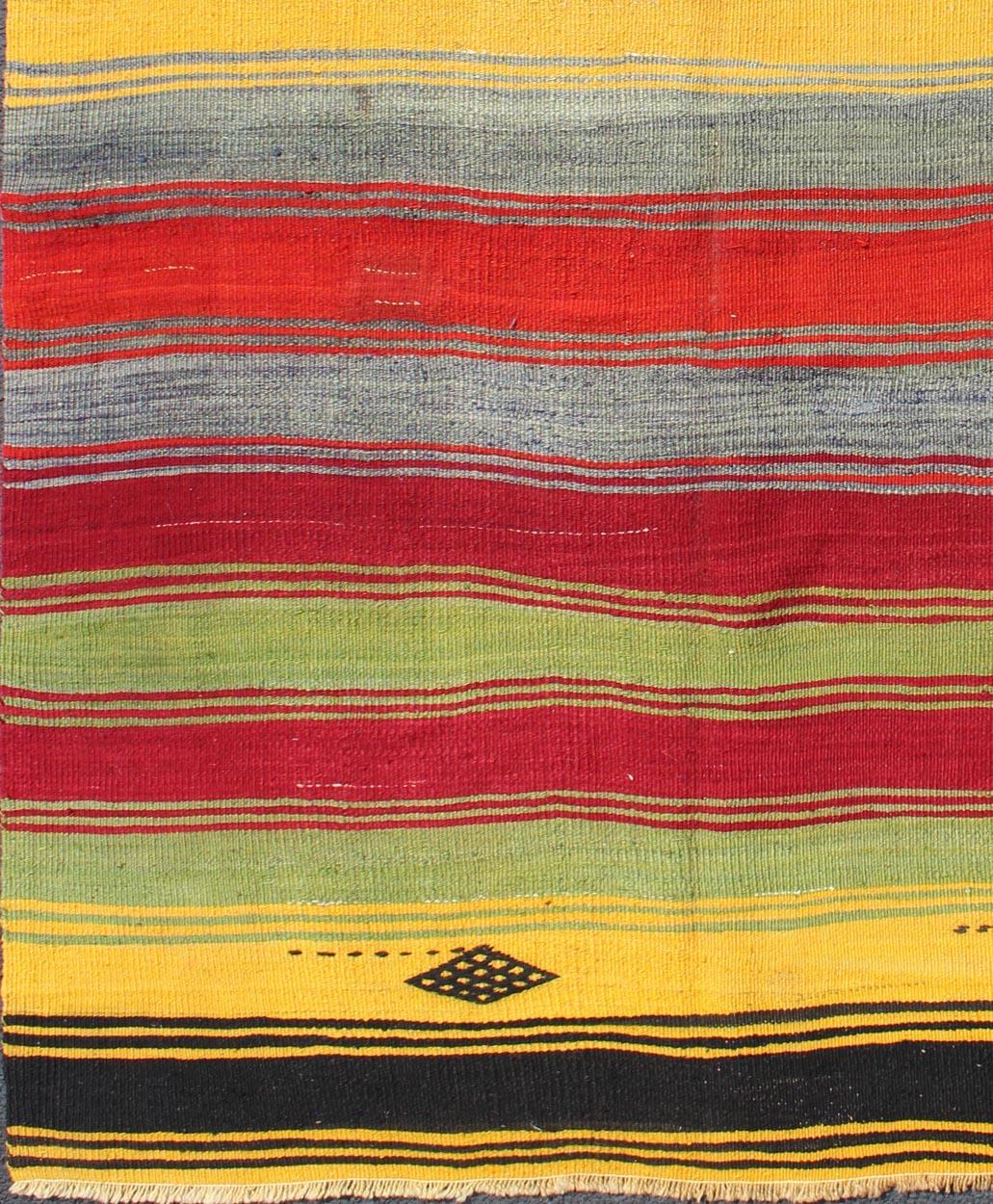 Colorful vintage Turkish Kilim rug with subtle tribal shapes and stripes design, rug mtu-95042, country of origin / type: Turkey / Kilim, circa mid-20th century

Featuring a repeating horizontal stripe design, with a few tribal motifs throughout,