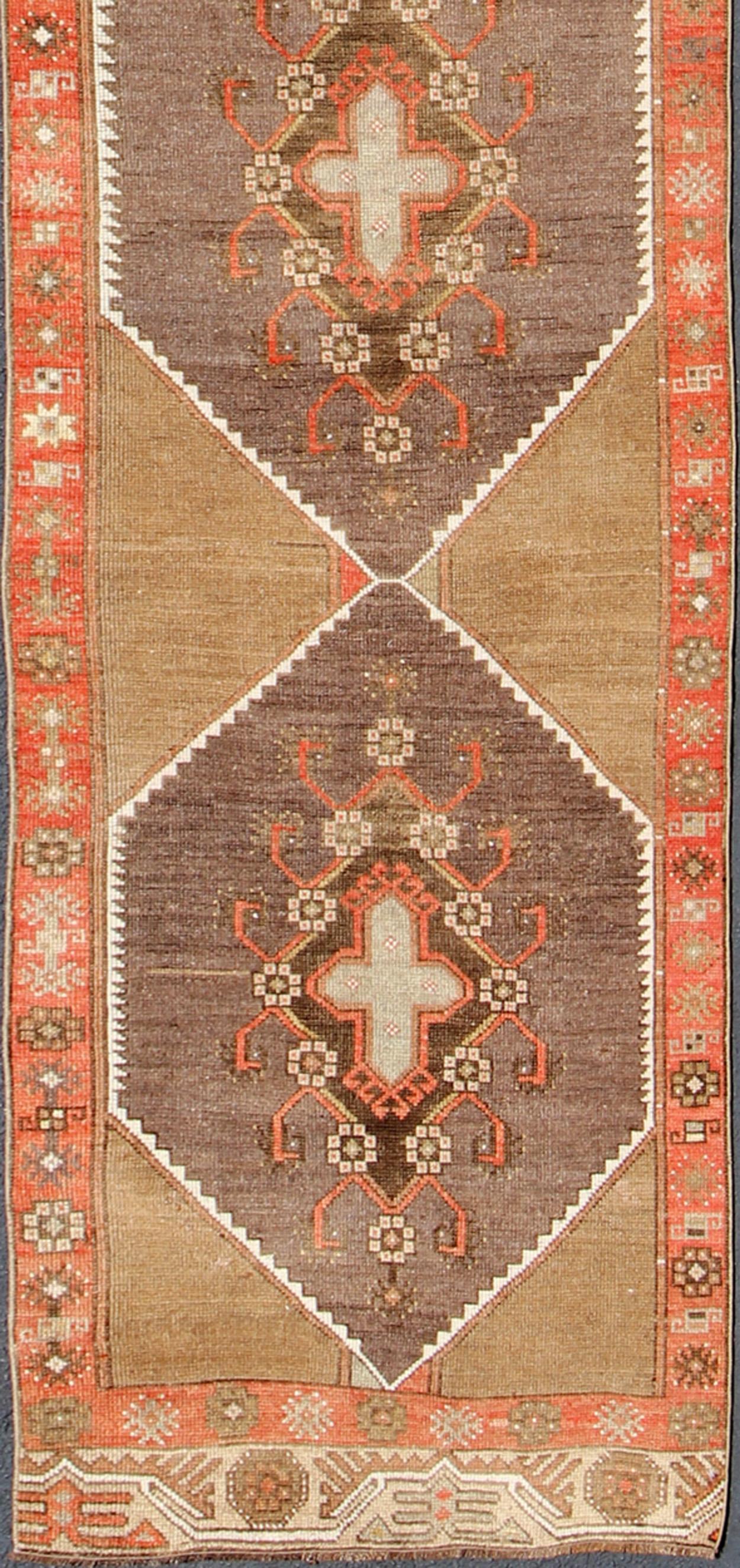 Long and narrow vintage runner from Turkey with multi geometric diamond medallion design in camel background, rust, gray, orange, brown and taupe. rug/TU-UGU-4808, country of origin / type: Turkey / Oushak, circa 1930

This vintage Turkish Oushak