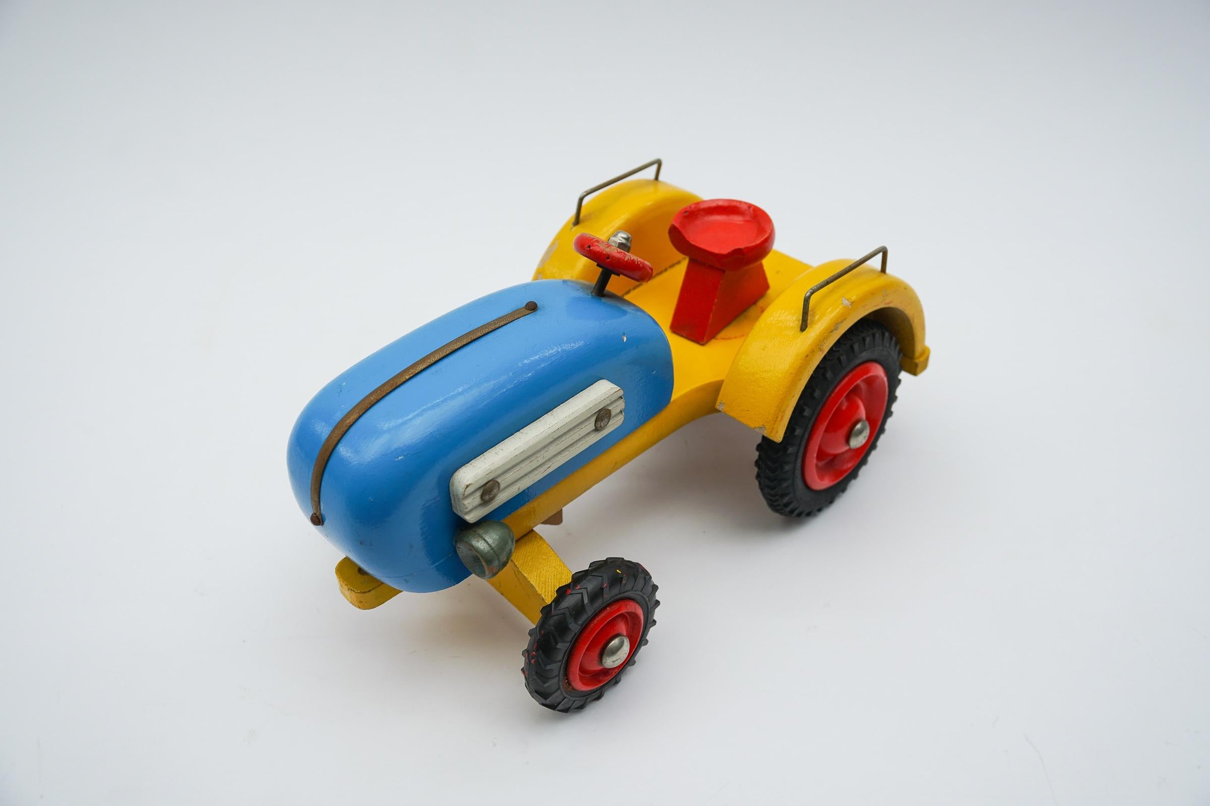 Old painted Waldorf school wooden toy tractor with movable front axle from Germany. 1950s / 1960s.