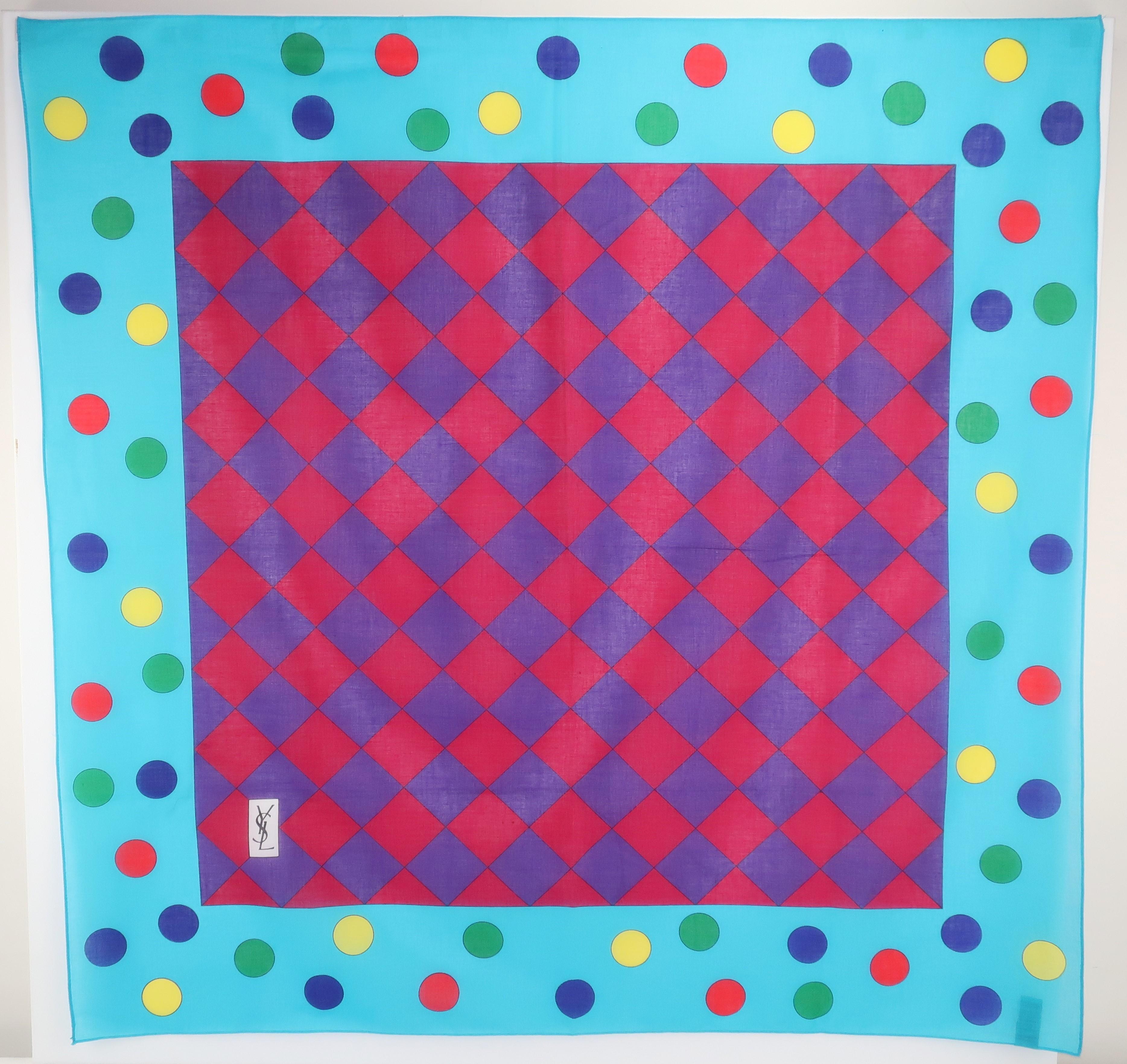 Wrap yourself in a colorful Yves Saint Laurent cotton scarf with a playful mix of polka dots and checkerboard squares all in shades of aqua blue, red, green, yellow, blue, purple and magenta.  Try mixing it with stripes for a stylish contrast or let
