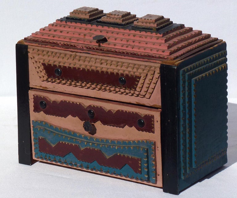 This is a colorfully painted tramp art box with a drawer and hinged lid. The construction is unusual. The upper, hinged portion is built around a cardboard cigar box. This was surrounded with 1/2