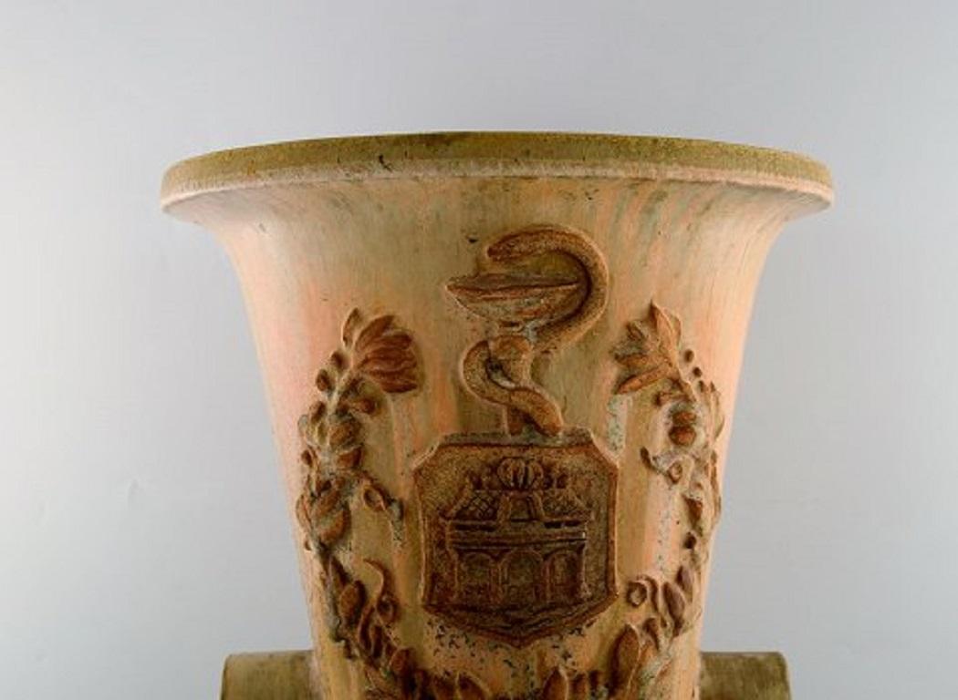 Colossal Arne bang einzigartige Vase aus glasierter Keramik mit einer Marke aus einer Apotheke in Aalborg, Dänemark. Datiert 1933. Geschmückt mit dem Äskulapstab als Symbol der Medizin.
Maße: 49 x 36,5 cm.
In sehr gutem Zustand.
Signiert und