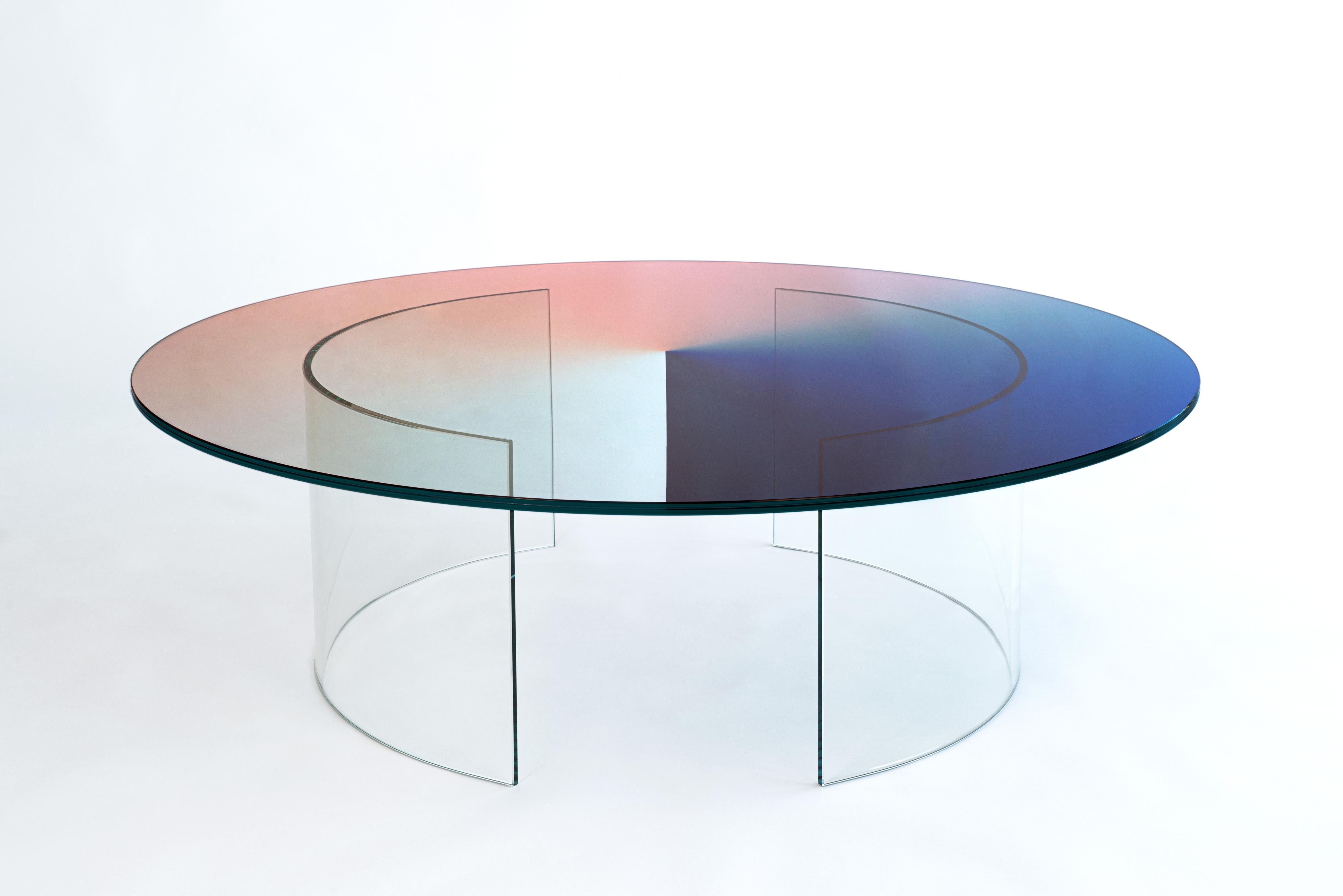 The Color Dial Curved table features a fully transparent glass top with bespoke curved legs that are attached to the top. The table is a sculptural feature that projects colour onto its surroundings and reflects intriguing patterns of light within