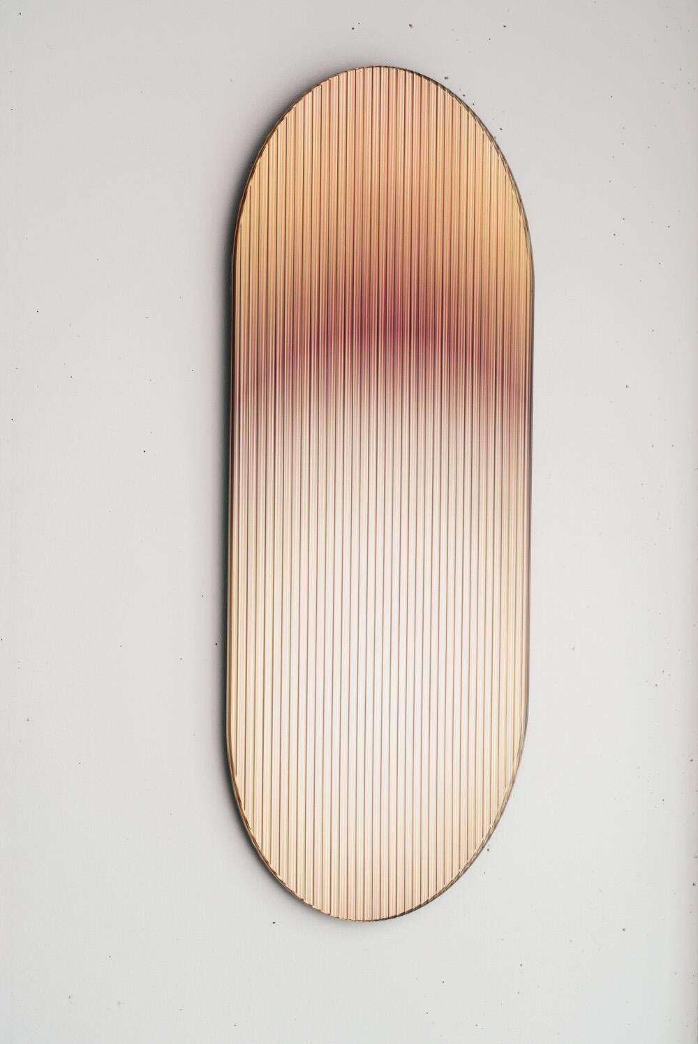 El panel de vidrio ondulado, reflectante y coloreado -diseñado para añadir una paleta de color a los espacios- refleja la luz en los espacios y añade movimiento y color a la vez que crea reflejos abstraídos. La pieza dispersa la luz a través de su