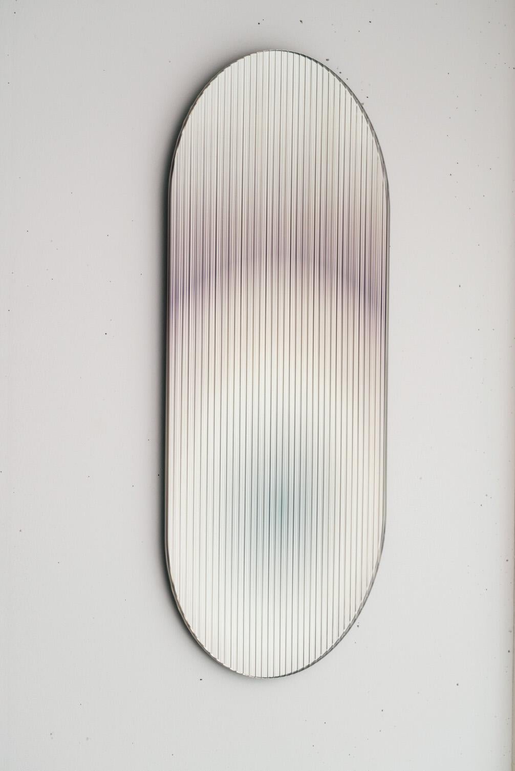 Il pannello di vetro increspato, riflettente e colorato di Rive Roshan - progettato per aggiungere una tavolozza di colori agli spazi - riflette la luce negli ambienti e aggiunge movimento e colore creando riflessi astratti. L'opera disperde la luce