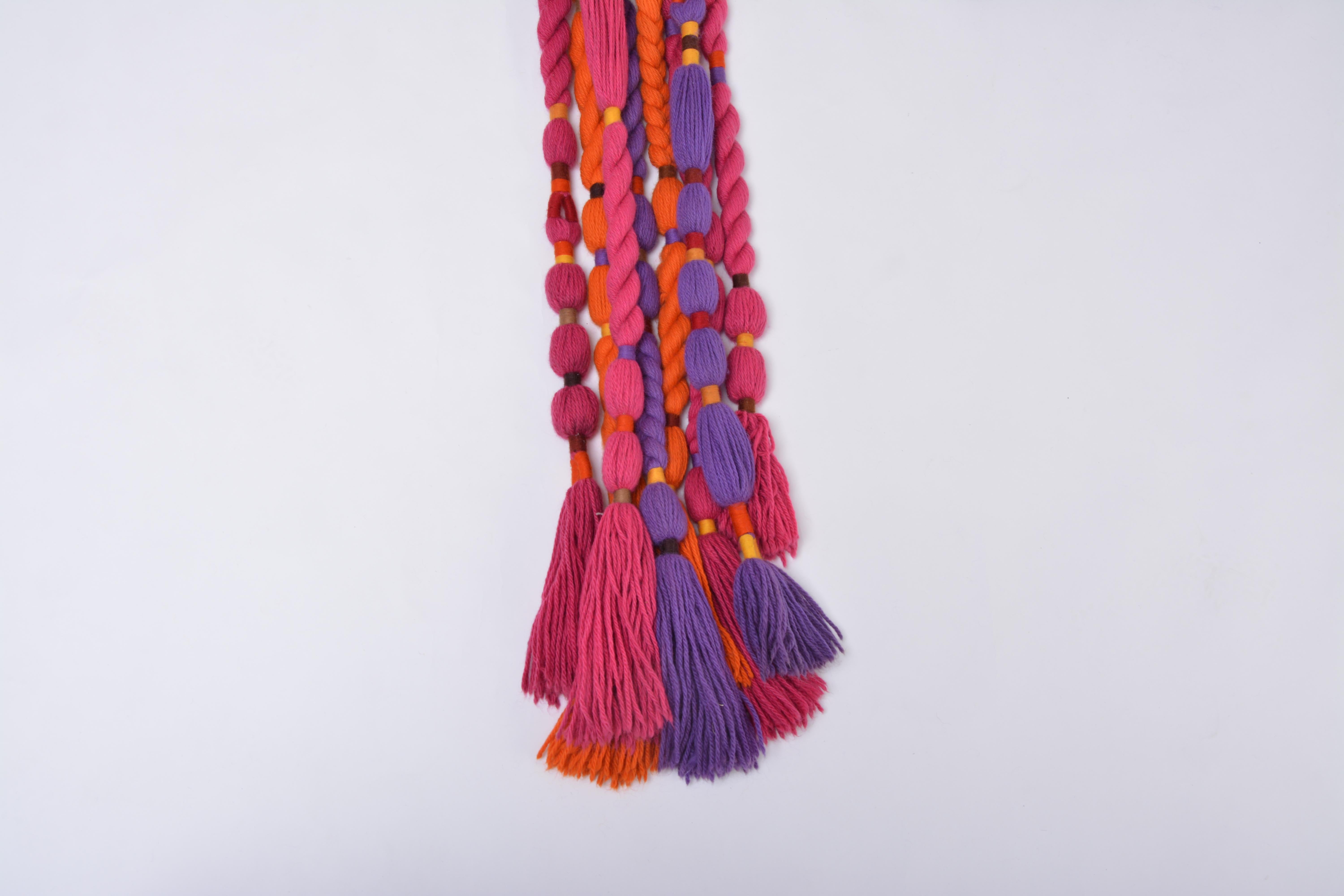 This gorgeous wall rug was designed in the 1970s by artist Ewald Kröner and manufactured by his own Label Schloss Hackhausen in Germany. Rectangular wall rug with eight long tassels made of wool in purple, pink and orange. A great example of a 1970s