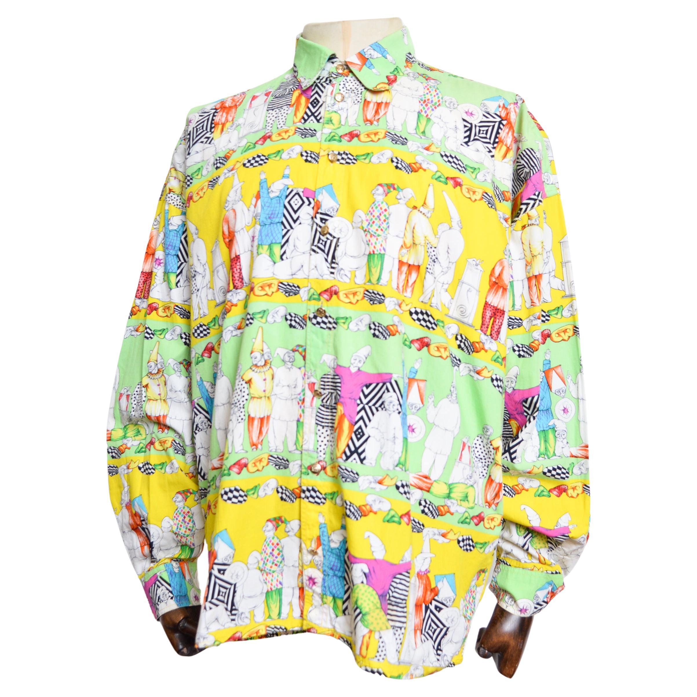 1990's Vintage 'Versace Jeans Couture' colourful patterned long sleeve Shirt, crafted from a printed cotton depicting lines of brightly decorated Pierrots, Garden Gnomes, Jesters and Clowns amongst vibrant green and yellow shades. 

MADE IN ITALY.  