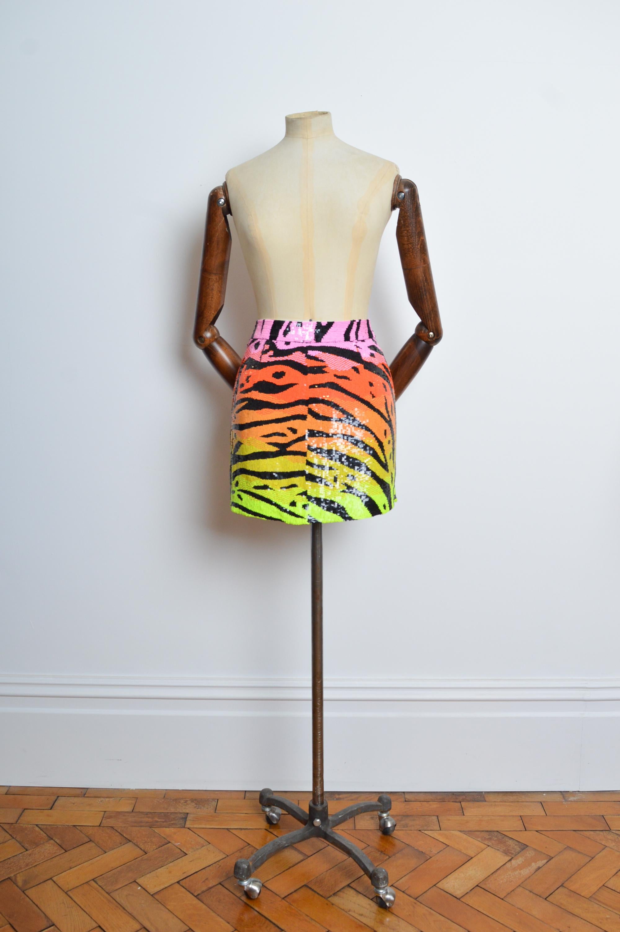 Superba, coloratissima minigonna a righe tigrate ASHISH Sequin Sunset Ombré (CIRCA 2010).
Completamente paillettato a mano da abili artigiani, il lavoro è divino.
Realizzato da Ashish in India.
Caratteristiche: fascia a vita alta, forma mini che