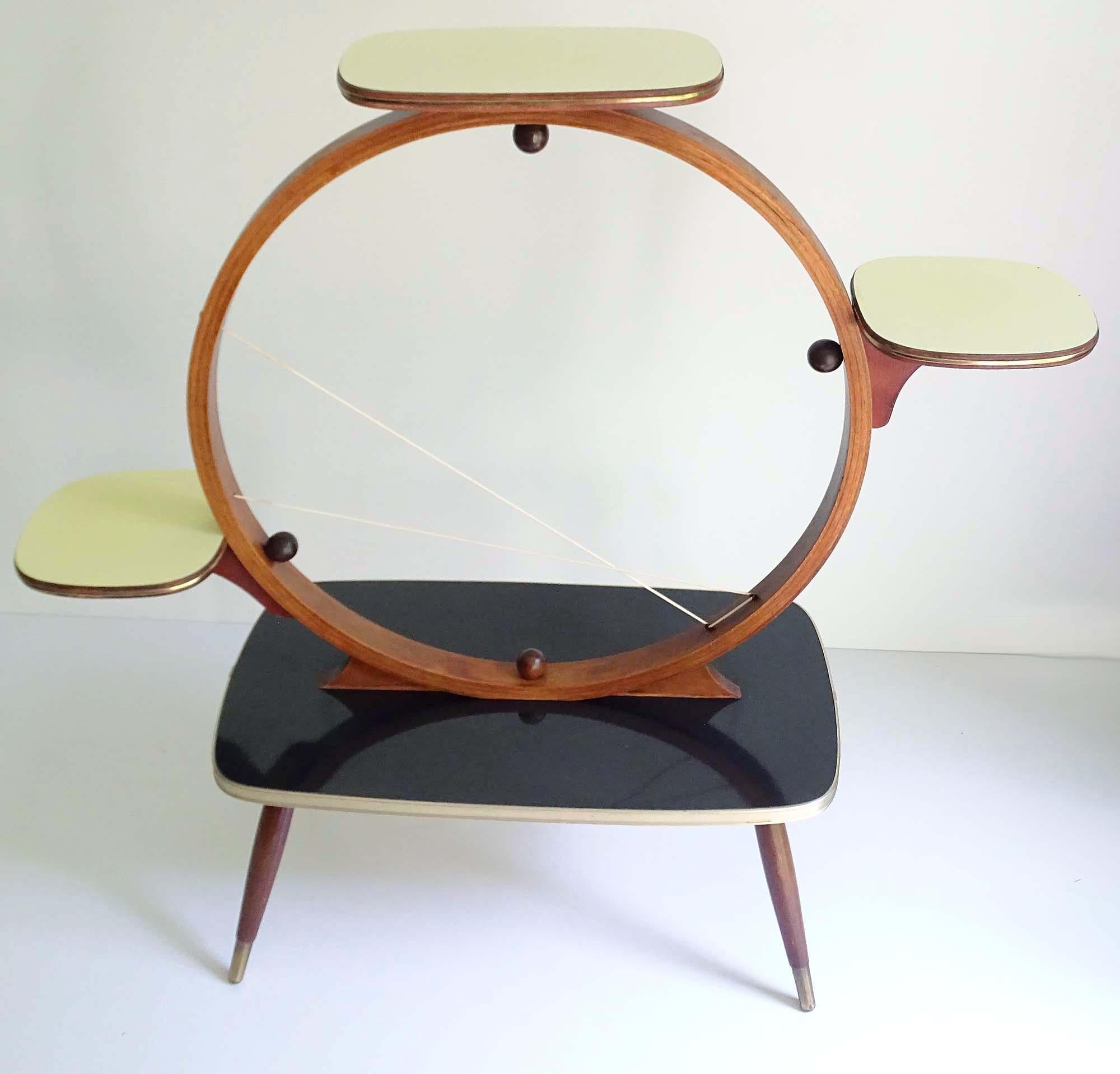 Stunning Mid-Century Modern flower / plant stand. This is an extremely rare quite large model. It features 1 large rectangular lower plate and 3 smaller plates, arranged in clockwise fashion on wooden circle structure, 2 synthetic bands for added