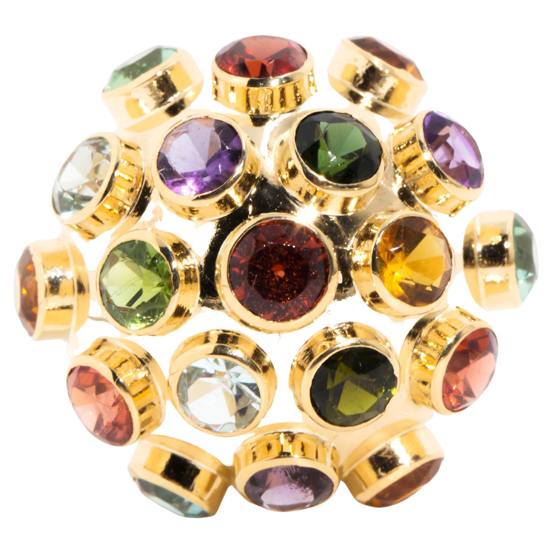 Forged in 18 carat yellow gold, this unique vintage dome ring features nineteen vibrant round gemstones set in a domed 