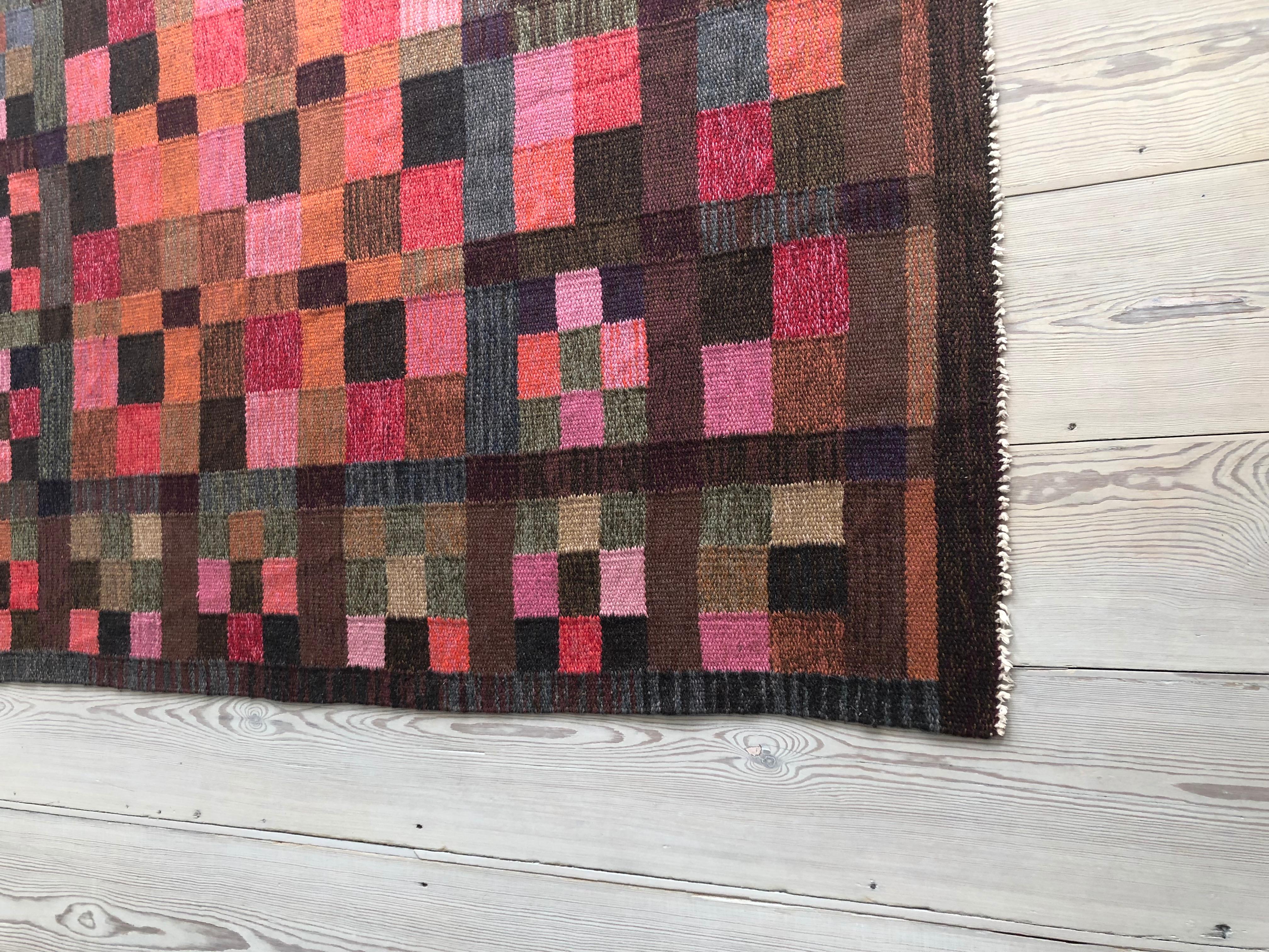 Flat-weave rug with pattern in colourful squares.