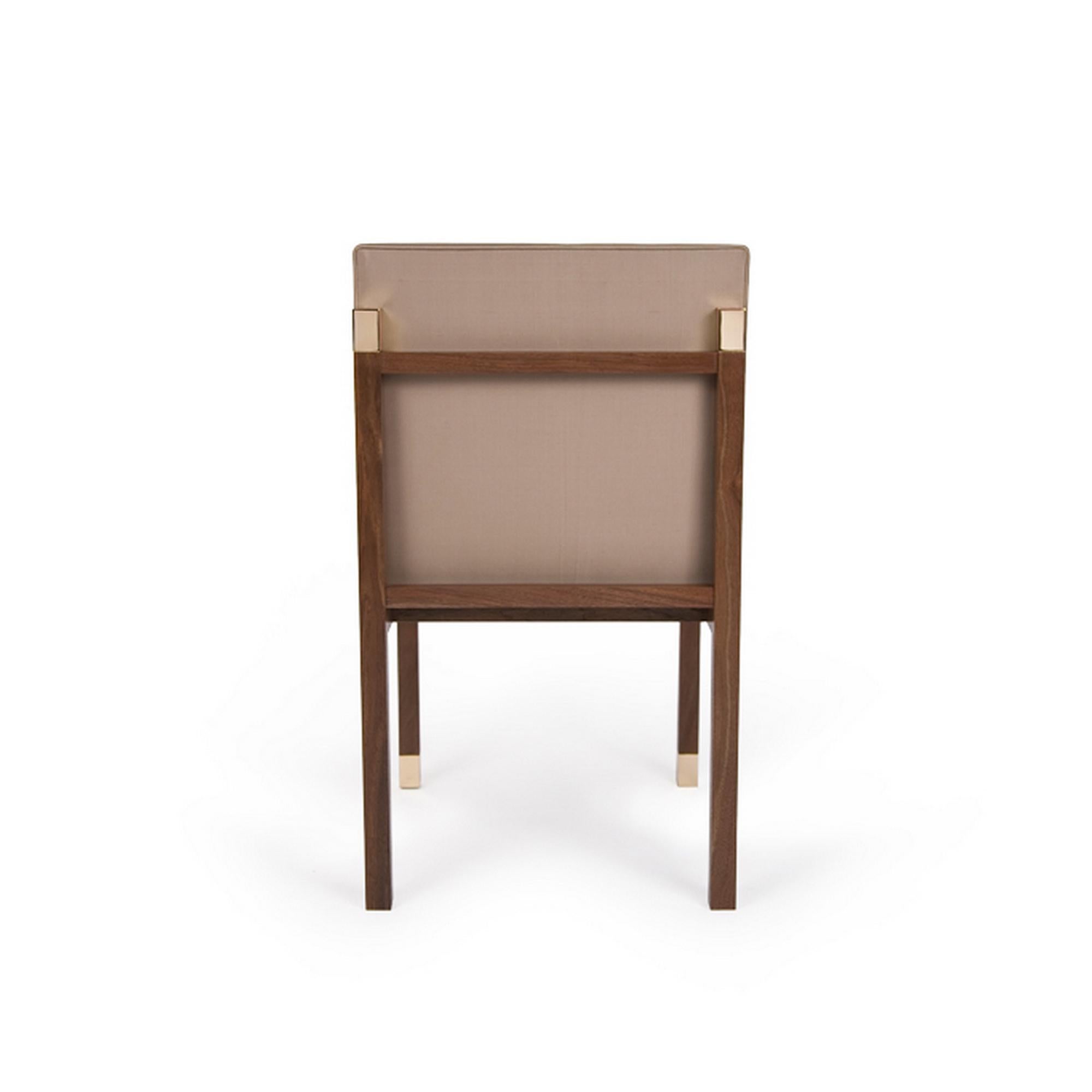 The Colt Chair pictured here consists of an organic walnut base, bronze caps, and finished with a beige fabric. The similarities in the beige and brown create a synergy for the colt chairs. Please do note that the fabrics are C.O.M.