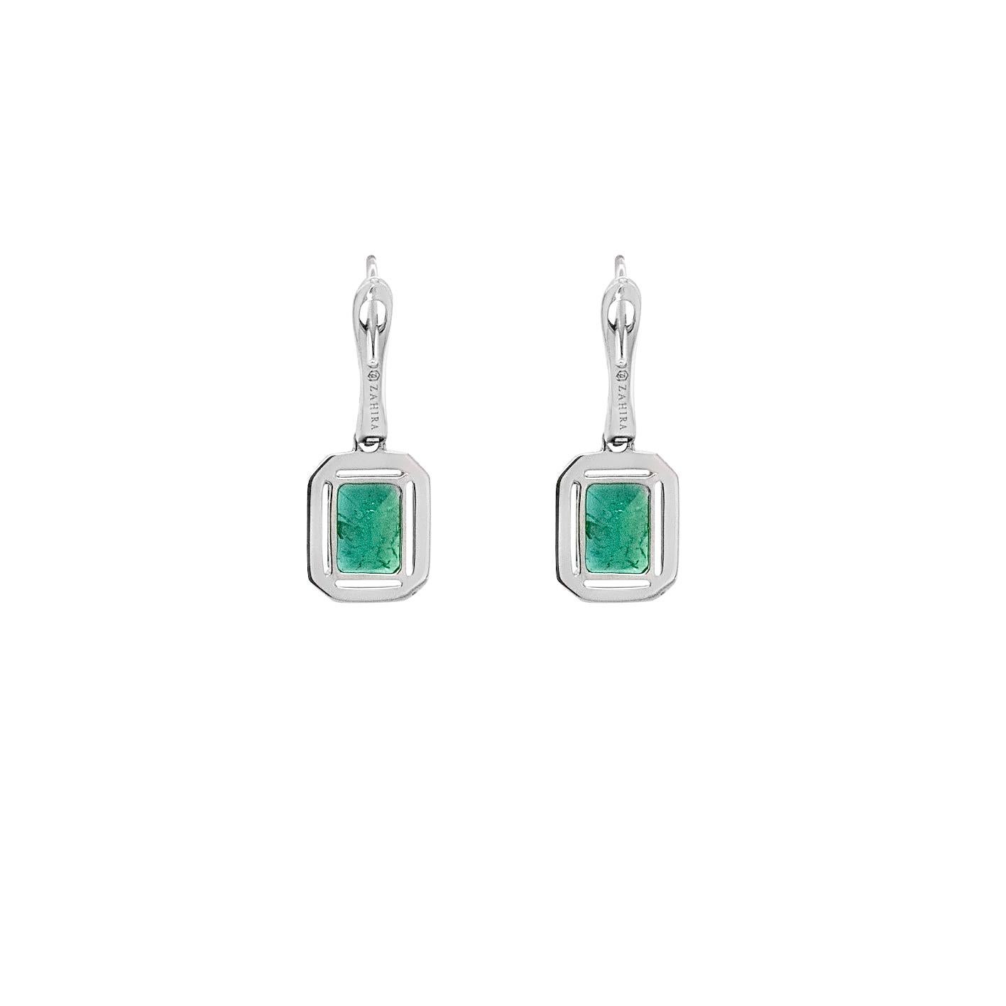 Questi orecchini pendenti in oro bianco 18 carati presentano 1,50 carati di smeraldi colombiani, apprezzati per la loro intensa tonalità verde. Ogni smeraldo è incorniciato da un'aureola di diamanti bianchi naturali, che aggiungono brillantezza e