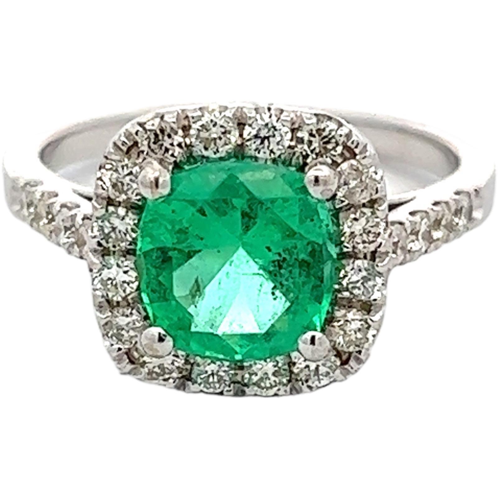 Beautiful green Colombian emerald diamond cocktail ring fashioned in 18 karat white gold. The 1.59 carat cushion cut Colombian emerald is GIA certified for origin and F1 minor clarity enhancement. The emerald is set in a halo mounting featuring