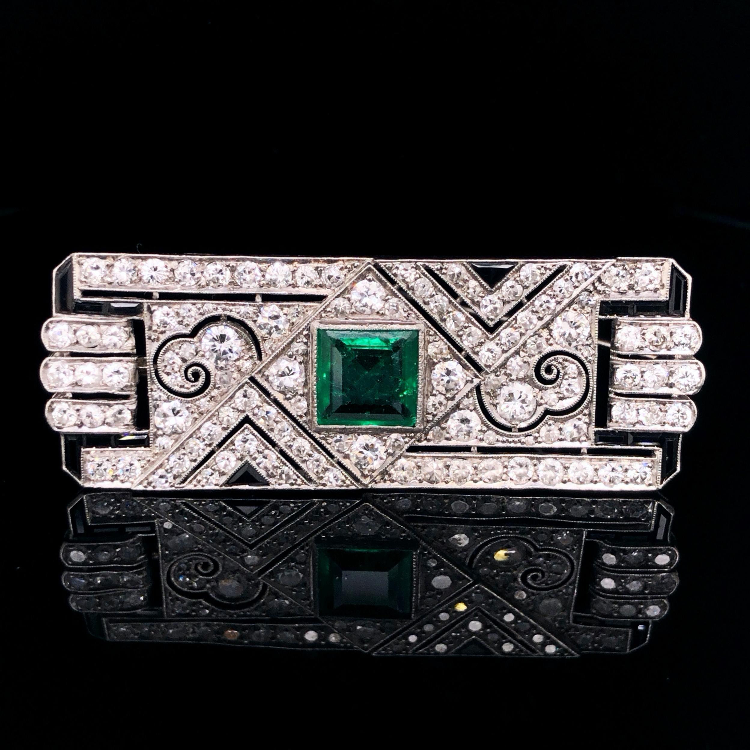 An emerald, diamond and onyx Art Deco brooch, ca. 1920, in platinum.

The facetted square emerald weighs 2.14 carats and is of Columbian origin. It has an old mine vivid green colour and crystal with fine jardin inclusions. The emerald is surround
