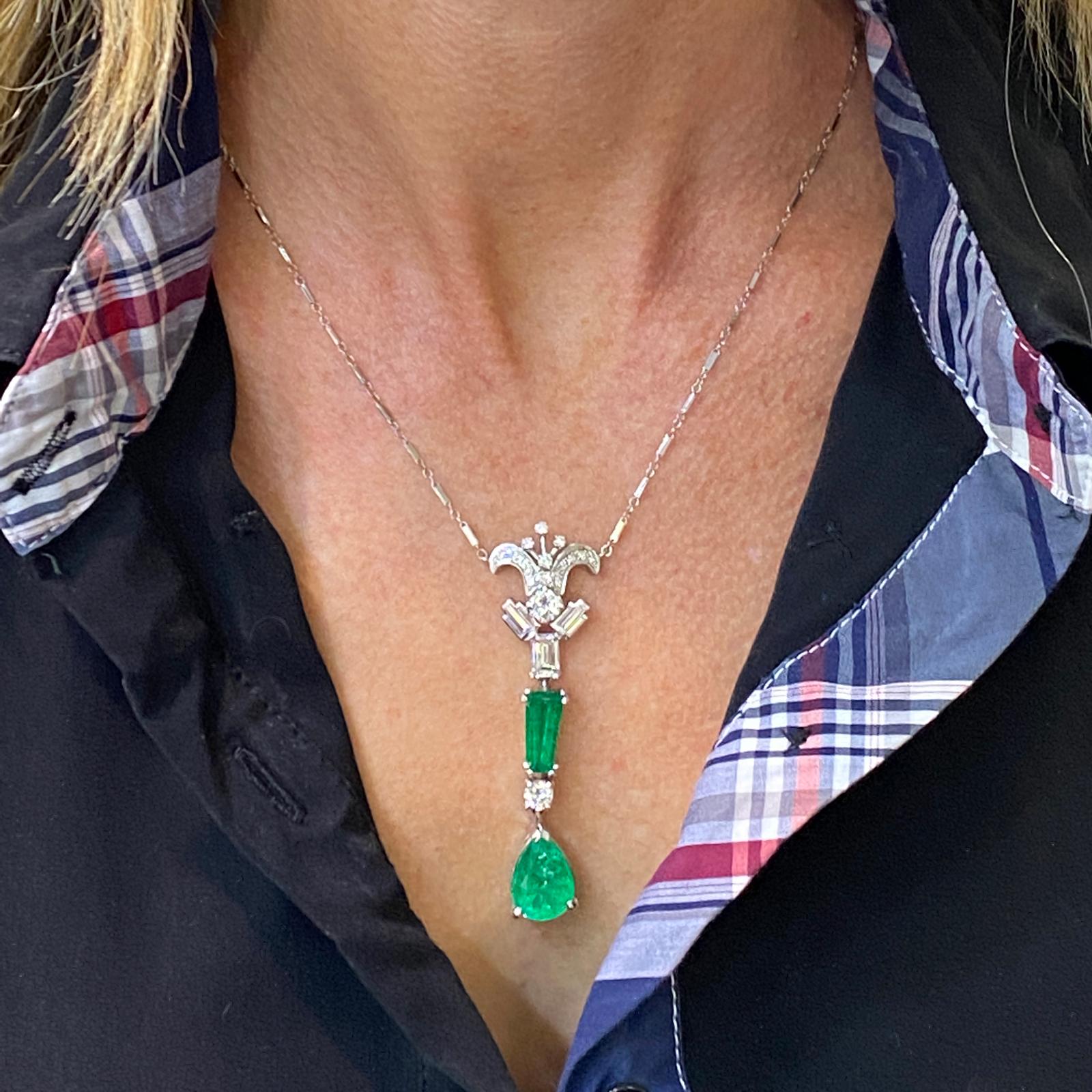 Gorgeous Colombian Emerald Diamond Vintage Necklace fashioned in 18 karat white gold. The drop pendant features 2 AGL certified Columbian emeralds. An approximately 6.50 carat pear shape and a 2.00 carat step cut modified briliant. The emerald is of