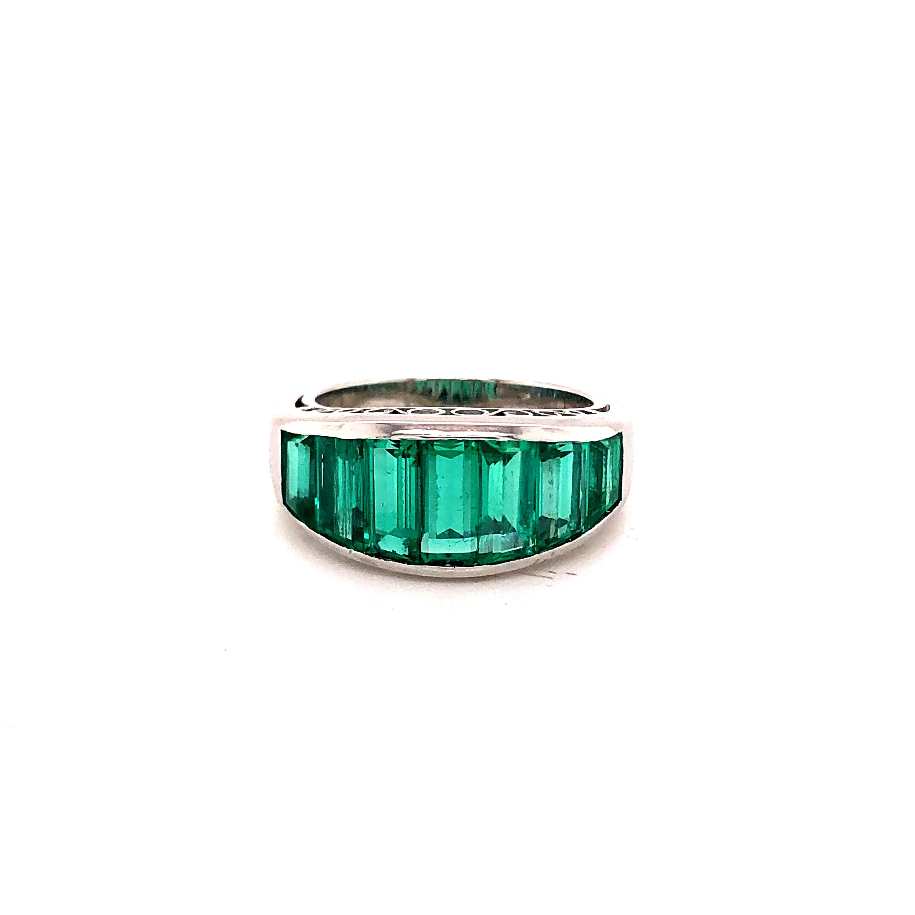 Amazing design on this platinum hand crafted Emerald gemstone step cut ring.  These Columbian Emeralds display a gorgeous green color. The gemstones vary in sizes as the graduate across the ring. Approximately 4.50 carats of emeralds are set into