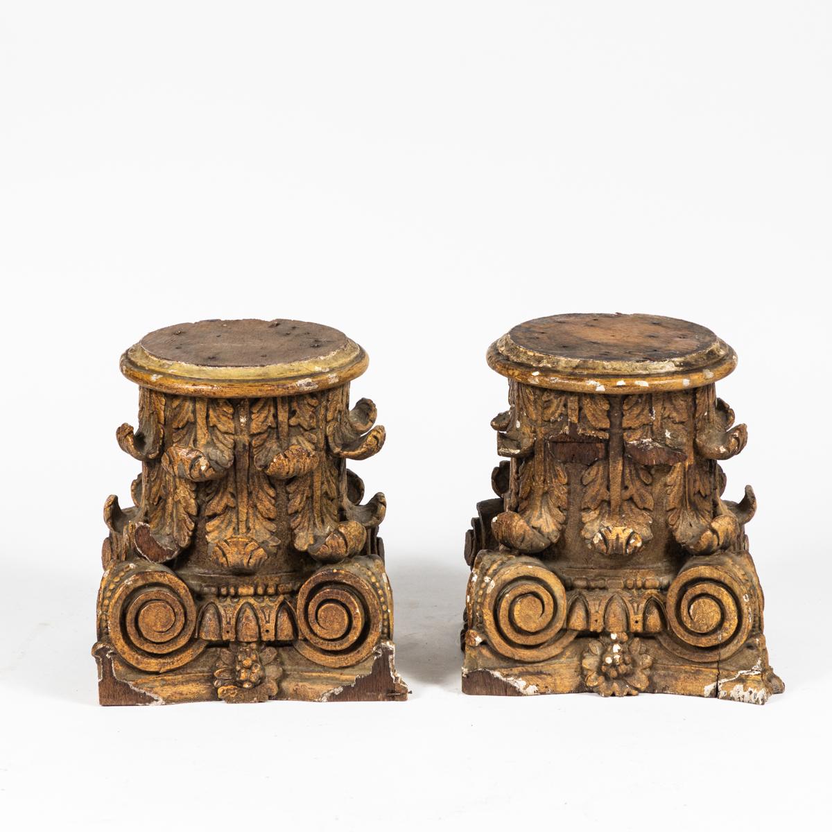 Pair of 19th-century wooden composite-style column capitals from France. These column capitals in the composite style would be great as a desk or bookcase accessory or on a mantlepiece. The gently worn finish juxtaposed with the classically formal