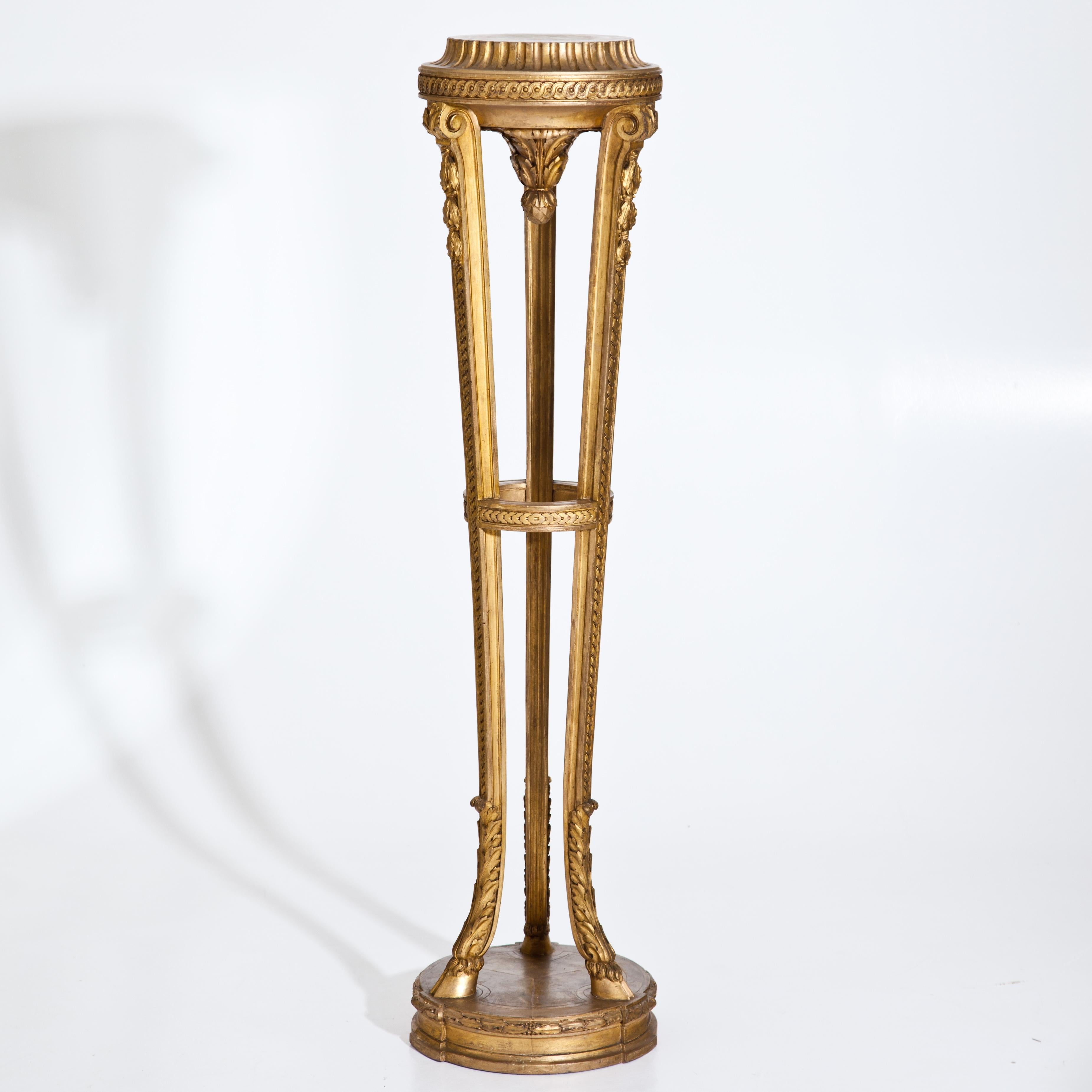Gold patinated column on a round base in the style of Louis Seize. The three legs are decorated with goat's feet with acanthus leaves and woven decorations in relief. The round shelf with further woven band and fluted fillet. The pendant in cone
