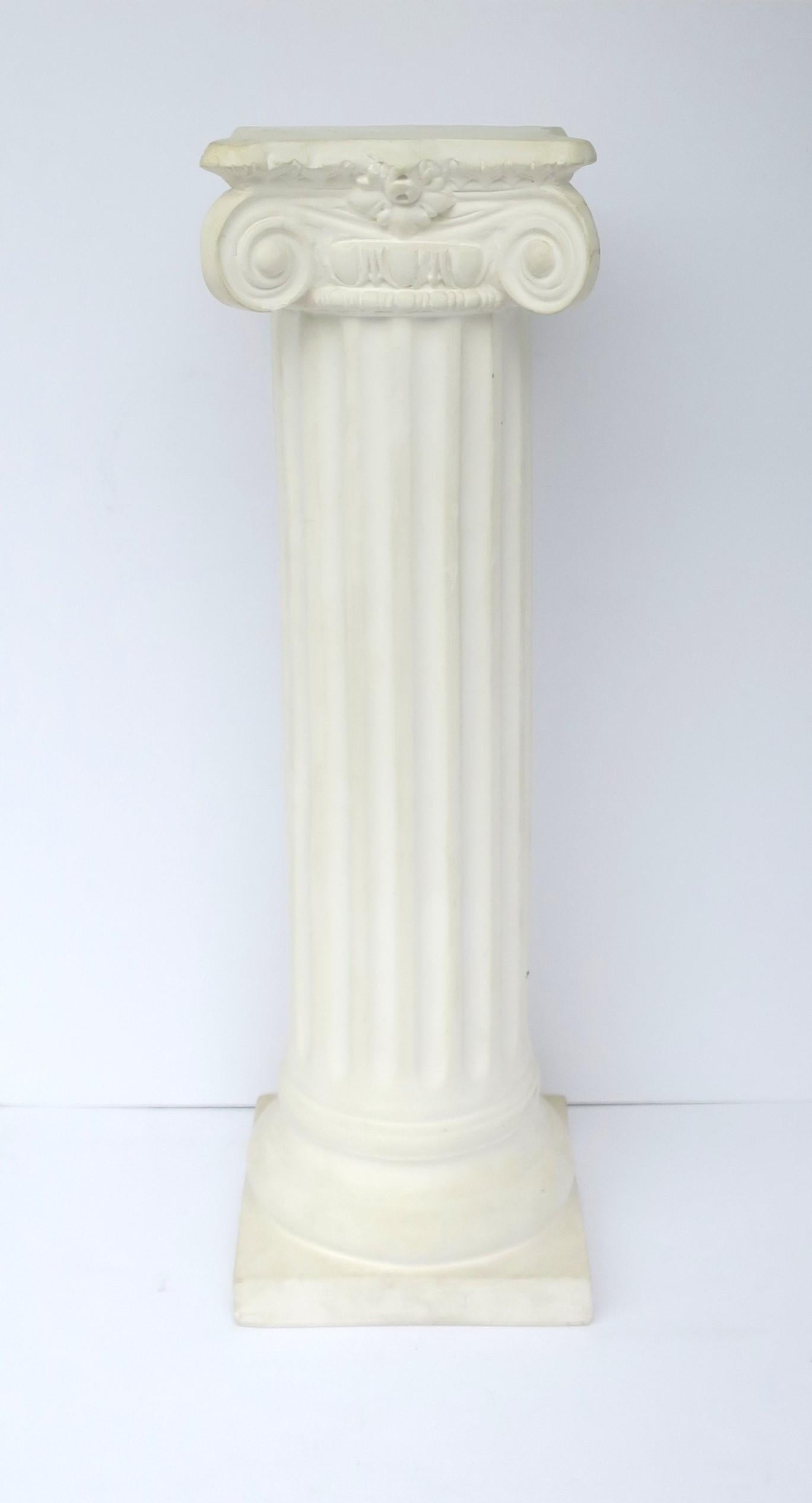 A white plaster fluted Grecian Ionic order column pillar pedestal stand in the neoclassical style, circa 20th century. Column has a matte unglazed surface. A great piece for a sculpture, plant, art, display, etc. 

Dimensions: 36.5