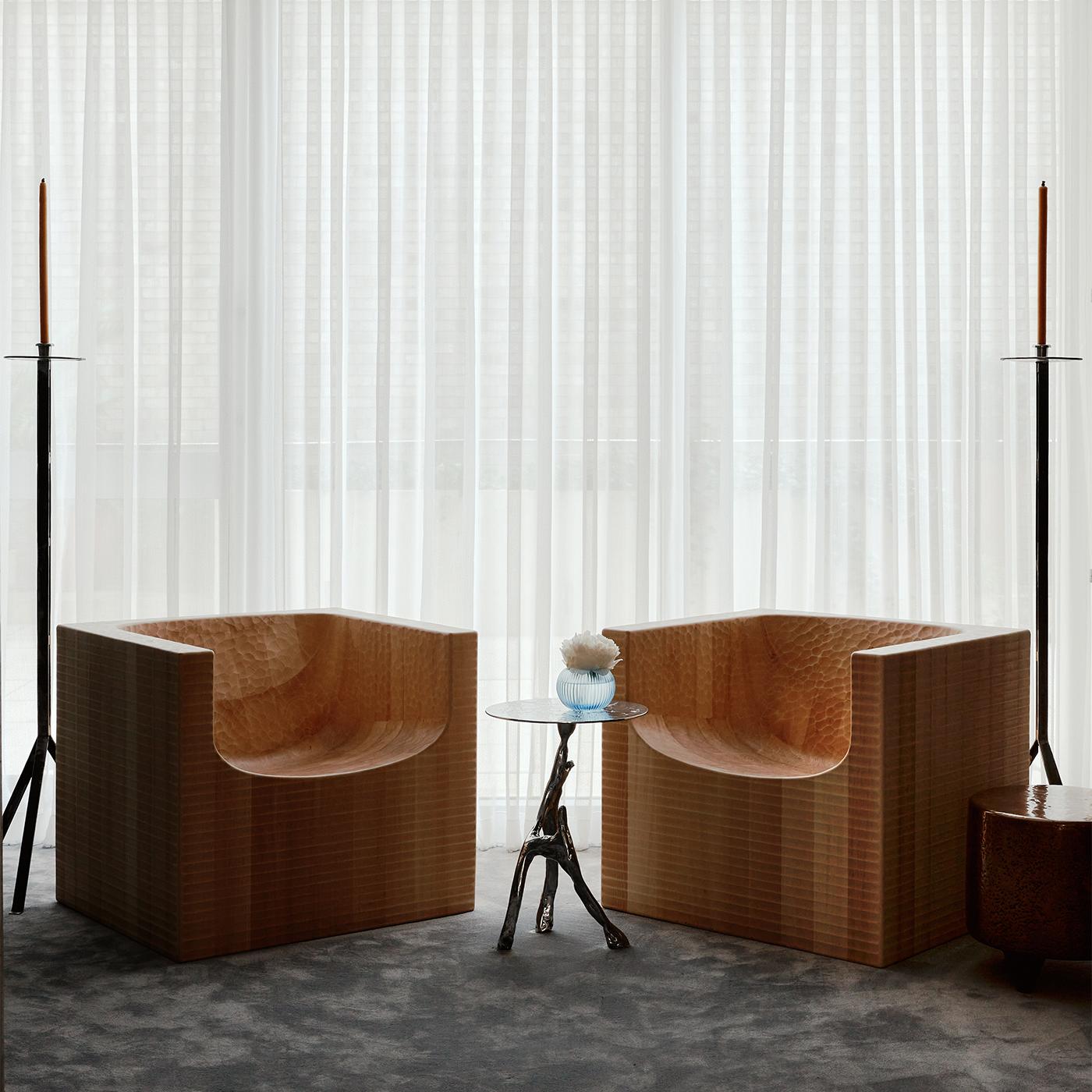 Testamento del diseño escultórico contemporáneo, este sillón ostenta una silueta monolítica hecha de fibras verticales de madera, cinceladas y acabadas a mano con una cepilladora. Con una textura refinada y única que celebra la artesanía