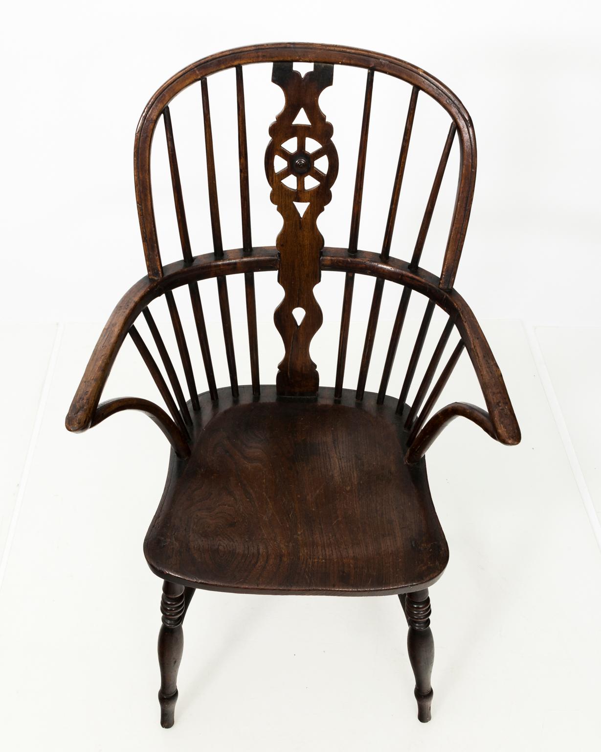 Windsor style comb-back armchair with a pinwheel design on the pierced back splat. The legs also feature ring turnings with an h-shaped cross stretcher, circa 19th century.
 