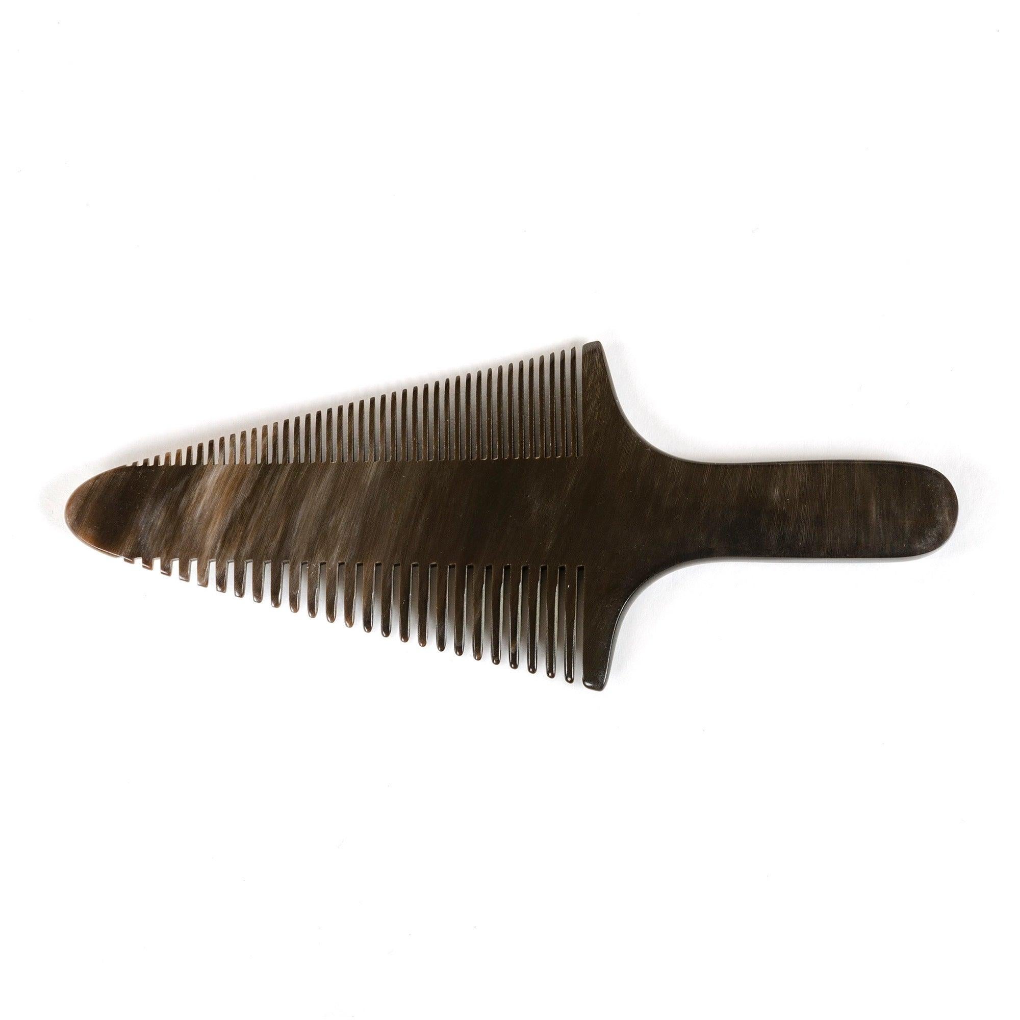 Un elegante pettine intagliato a mano in corno di mucca con variazioni di colore e motivi naturali.