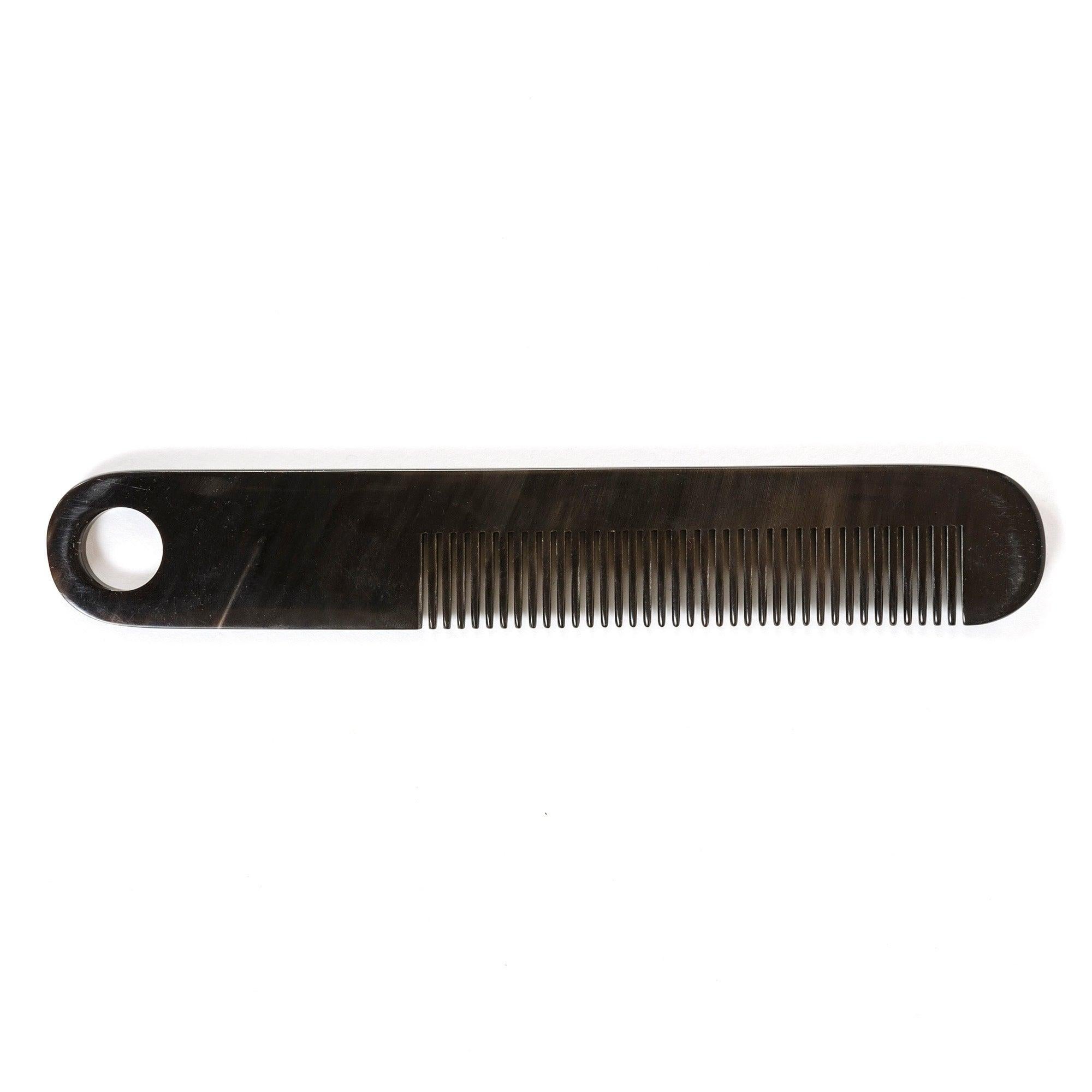 An elegant comb hand-carved from cow horn with naturally occurring variations in color and pattern.