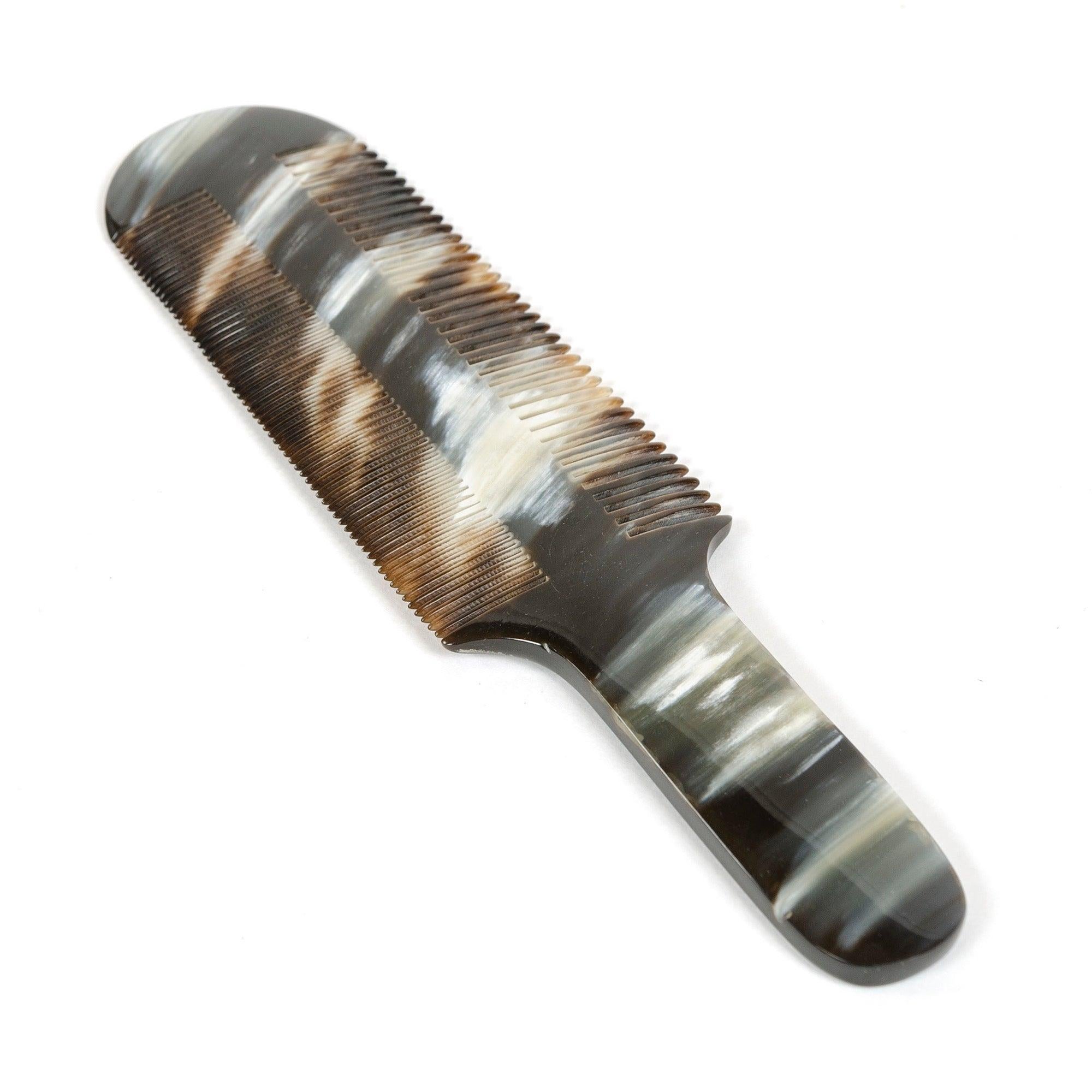 Un elegante pettine intagliato a mano in corno di mucca con variazioni di colore e motivi naturali.