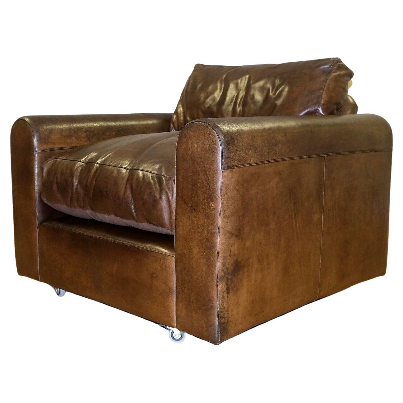 We are delighted to offer for sale this comfortable Alma Home brown leather armchair with wheels. 

The stylish armchair is presented with square arm rest, timeless distressed finish, feather filled backrest and seat cushion altogether with a deep