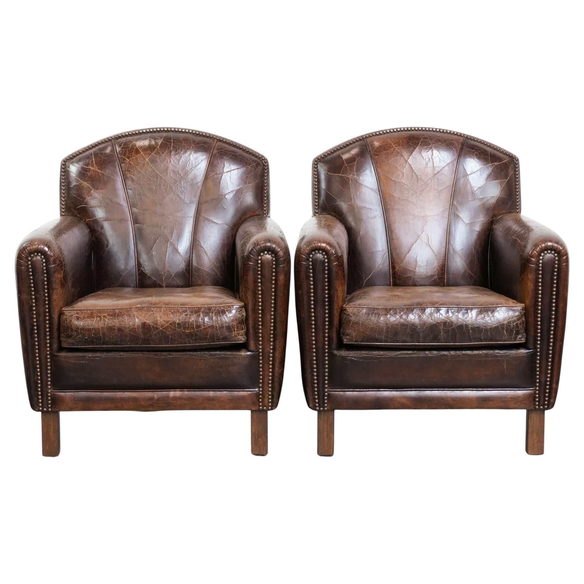 Comfortable and sturdy set of 2 cowhide leather armchairs with character