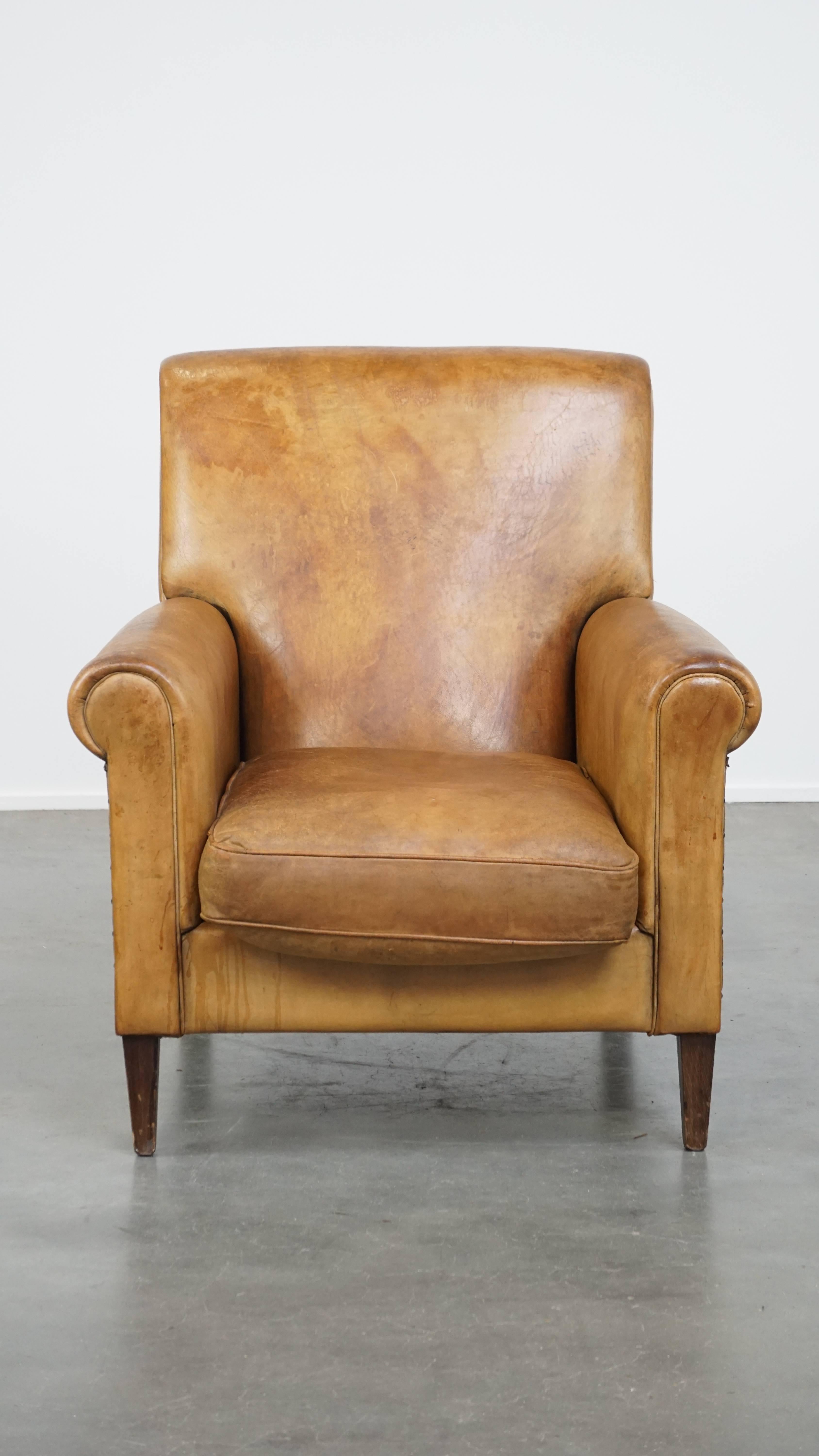 This amazing sheepskin leather armchair can easily fit into almost any interior. With its straight lines and beautiful patina, this vintage armchair has a characteristic and stylish appearance. It is finished with decorative nails on both sides and