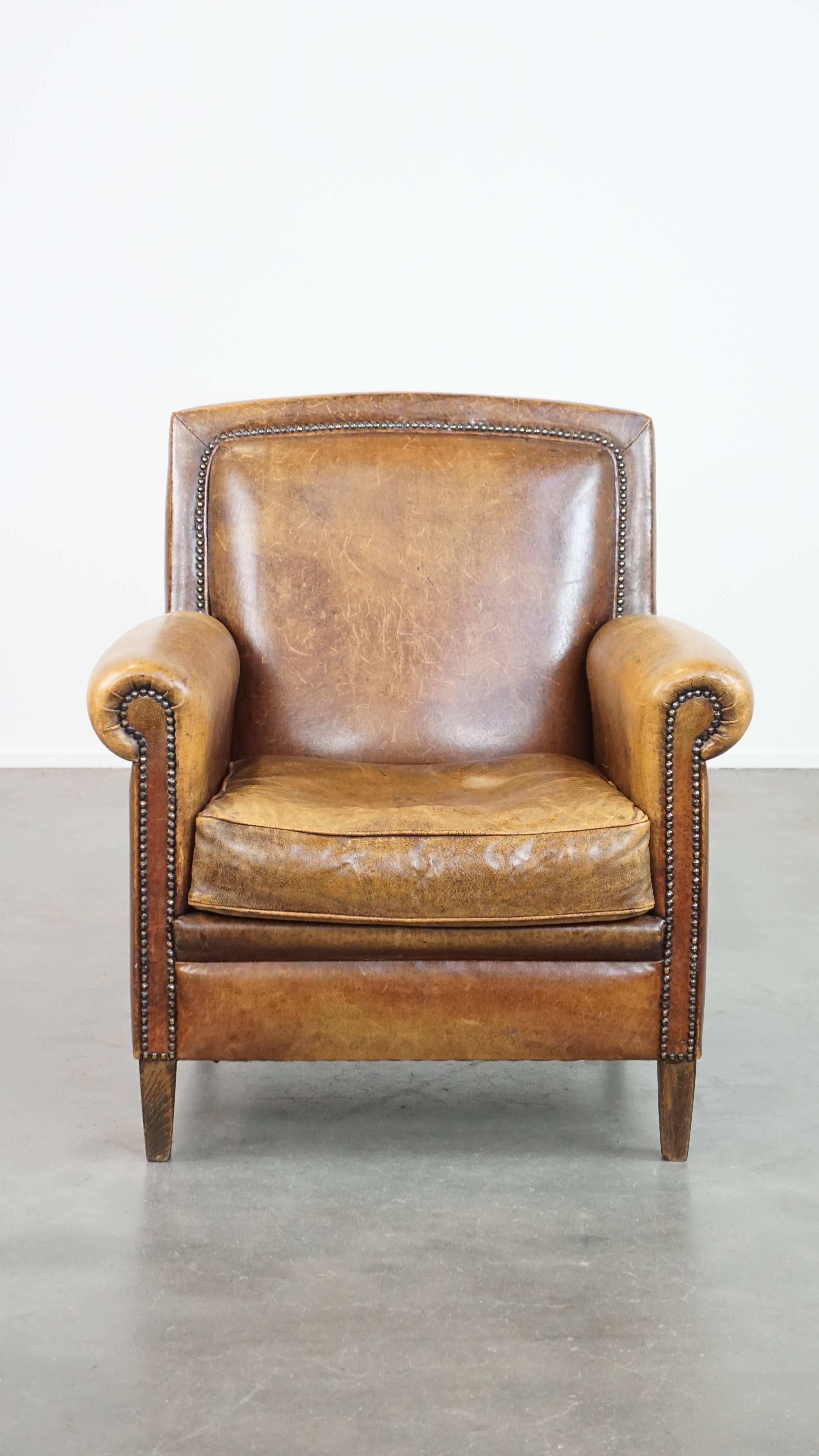 Con il suo design affascinante e di carattere, questa poltrona in pelle di pecora è un gioiello senza tempo a cui nessuno può resistere. I chiodi decorativi sul retro e il motivo a punto sul lato aggiungono un tocco di lusso al suo aspetto