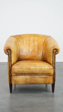 Comfortable, charming leather English-style club chair in a light color scheme
