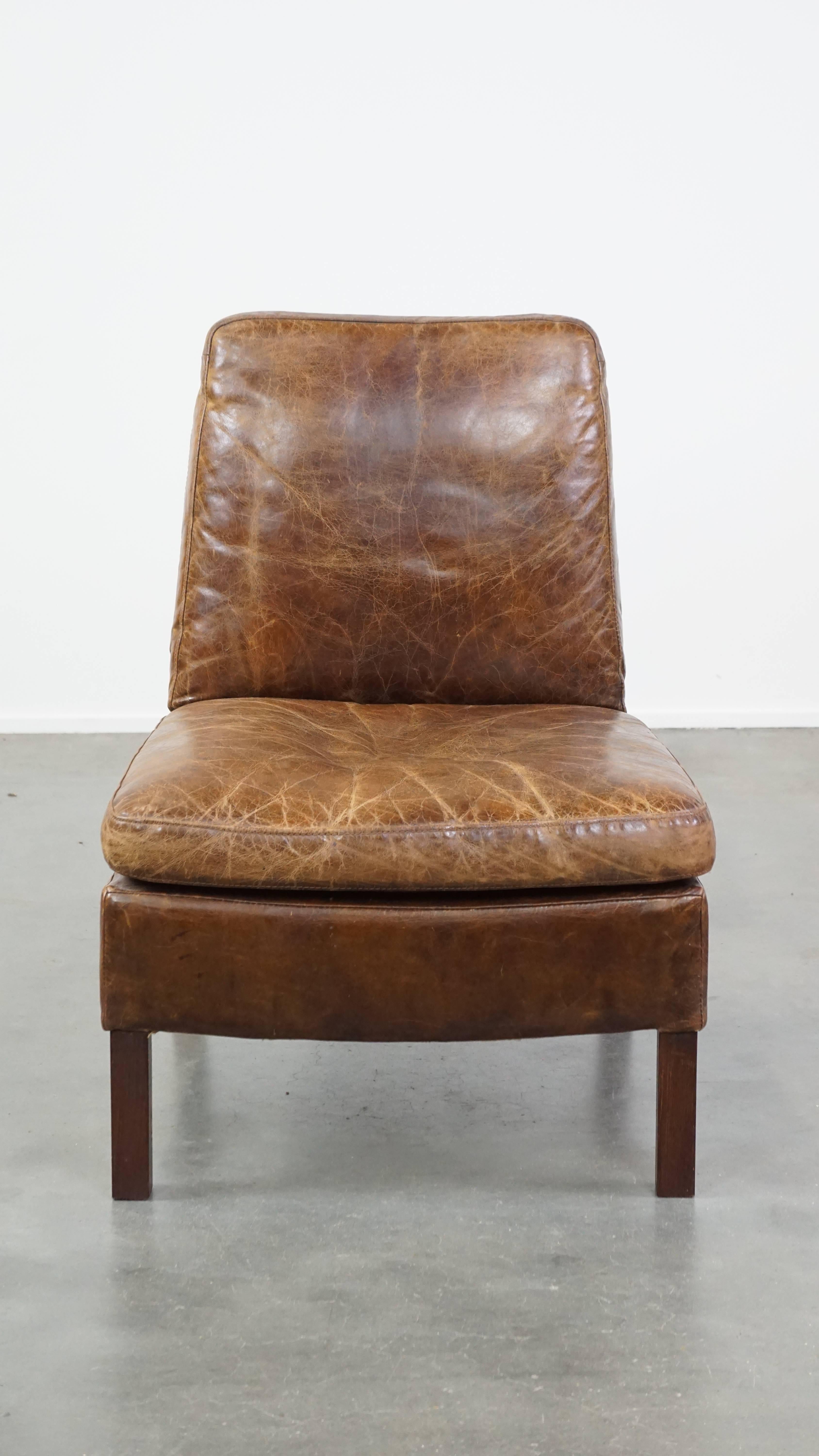 This fantastic cow leather armchair/lounge chair is full of character and a true eye-catcher. With its unique design, featuring no armrests, it doesn't compromise on comfort – quite the opposite! The chair has a fixed back and seat cushion, offering