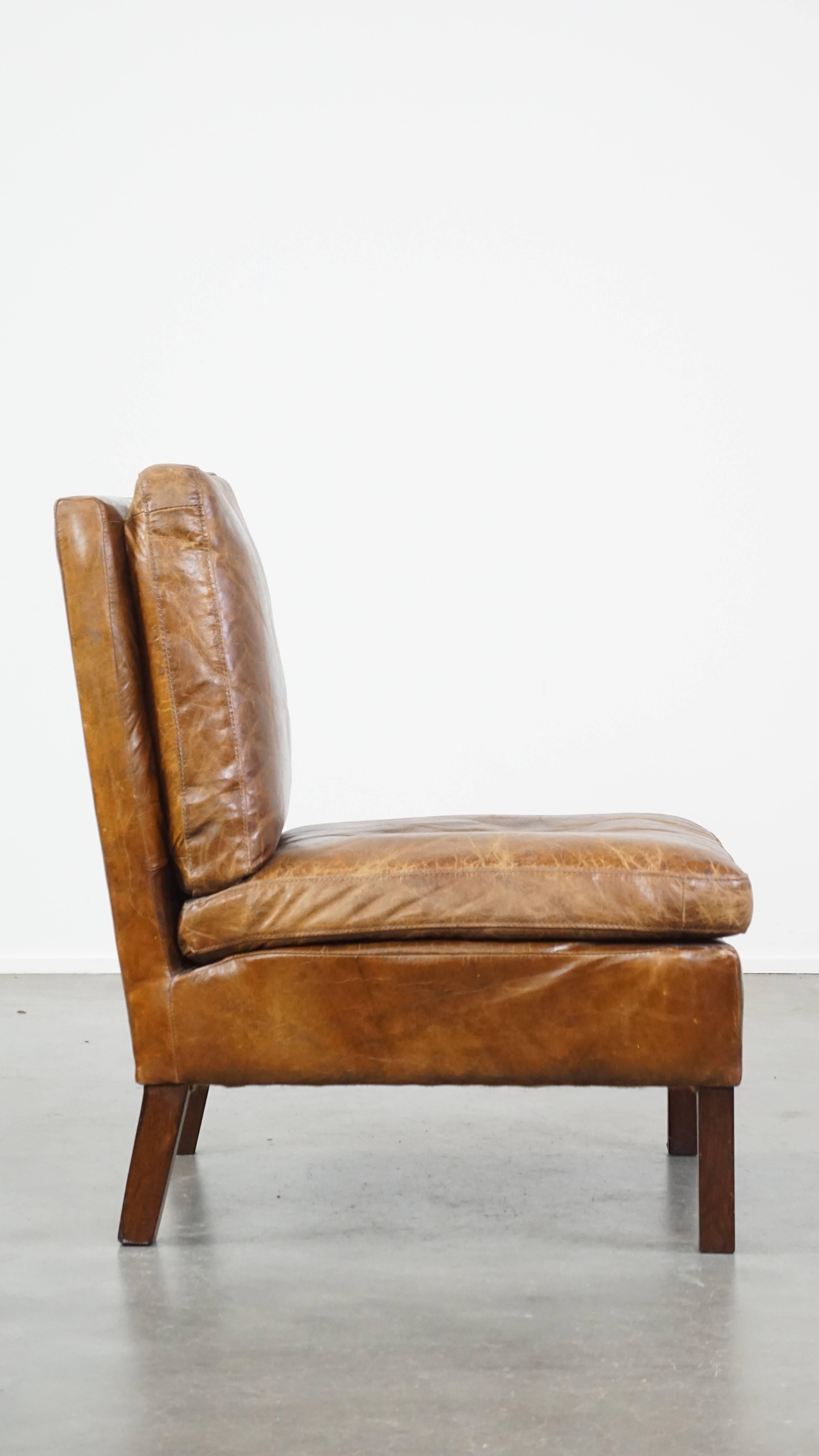 Hand-Crafted Comfortable cow leather lounge chair with a unique design and beautiful patina For Sale