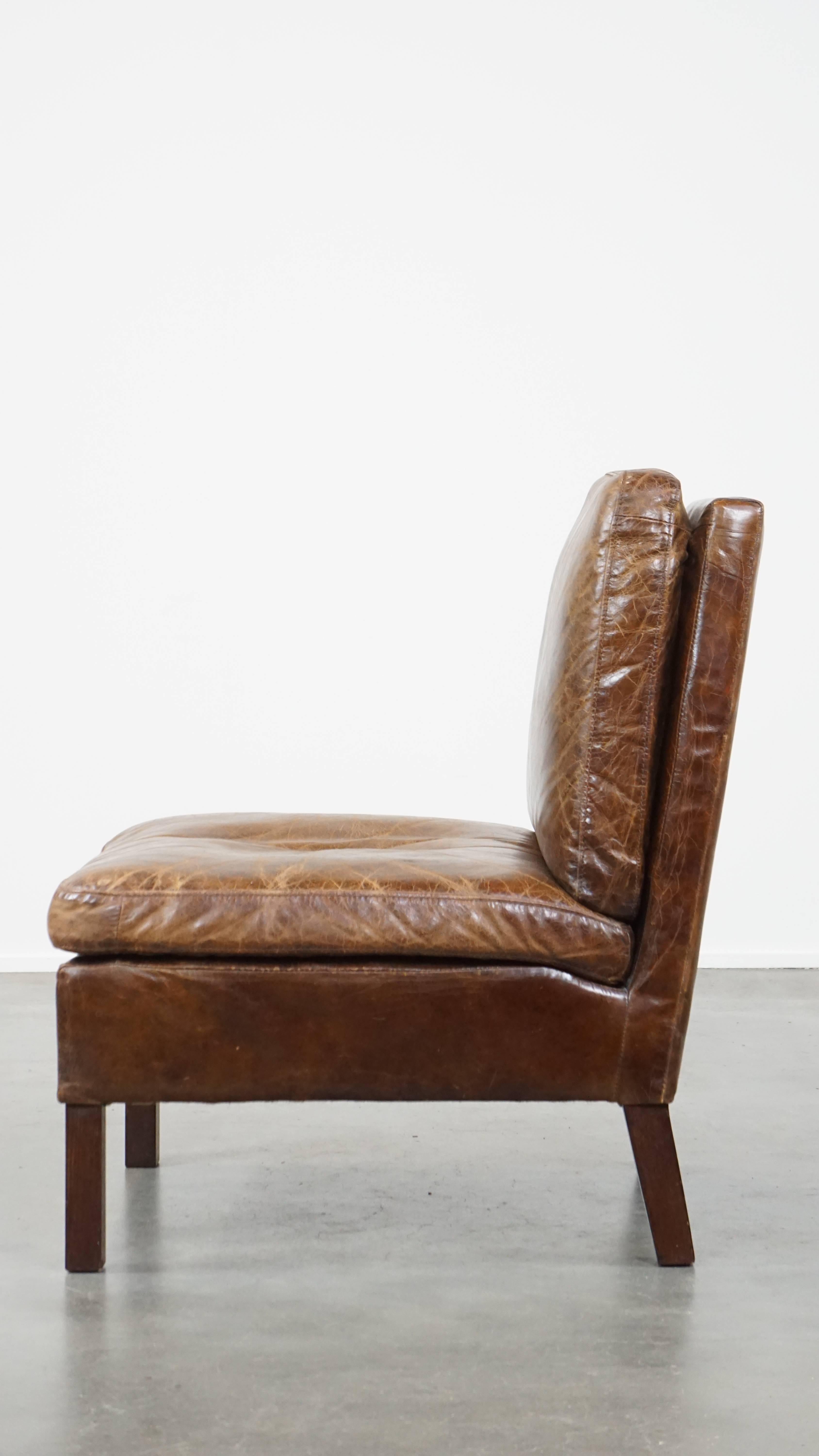 20th Century Comfortable cow leather lounge chair with a unique design and beautiful patina For Sale