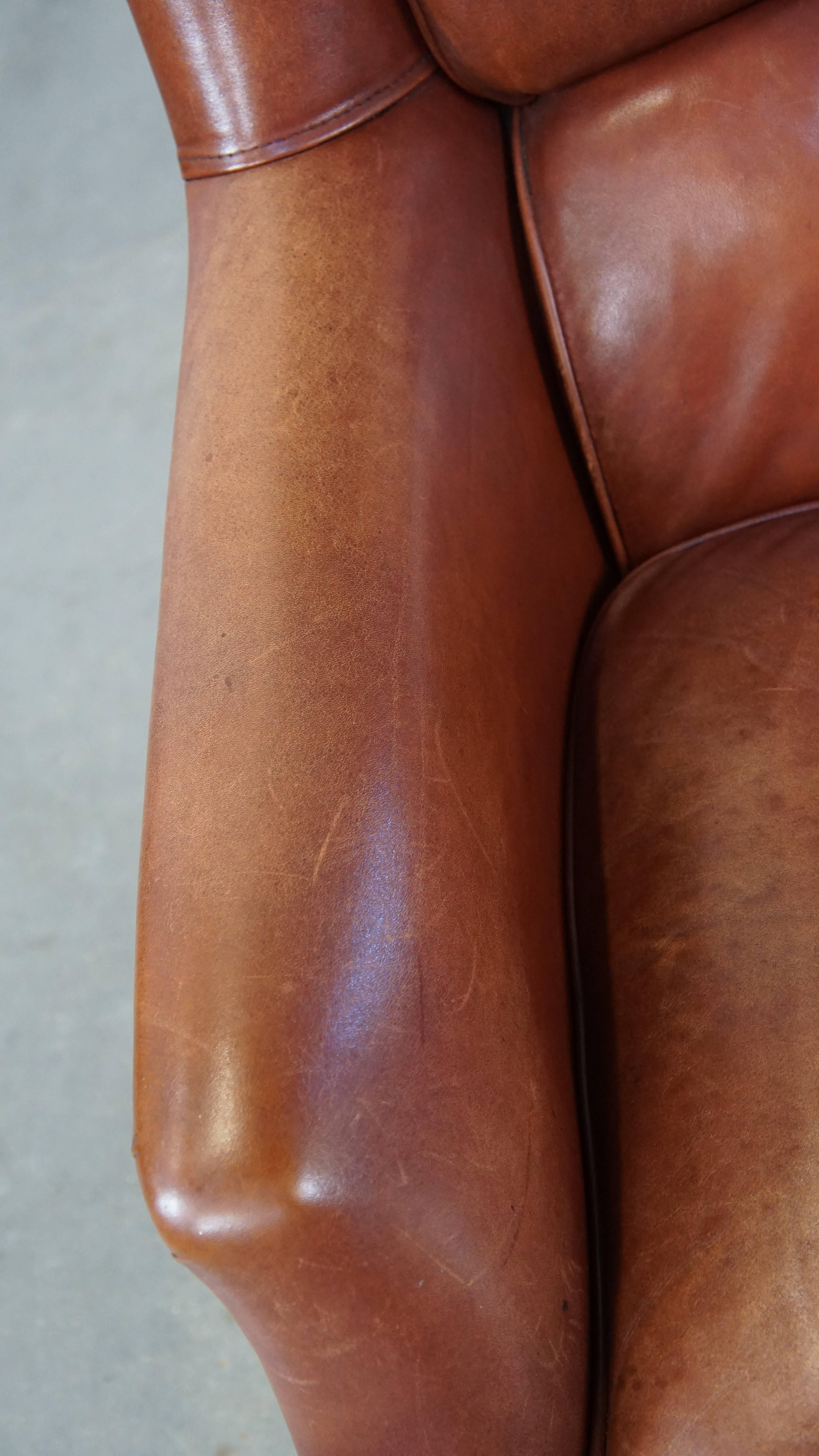 Fauteuil confortable en cuir de vache en bon état, fini avec des clous décoratifs en vente 1