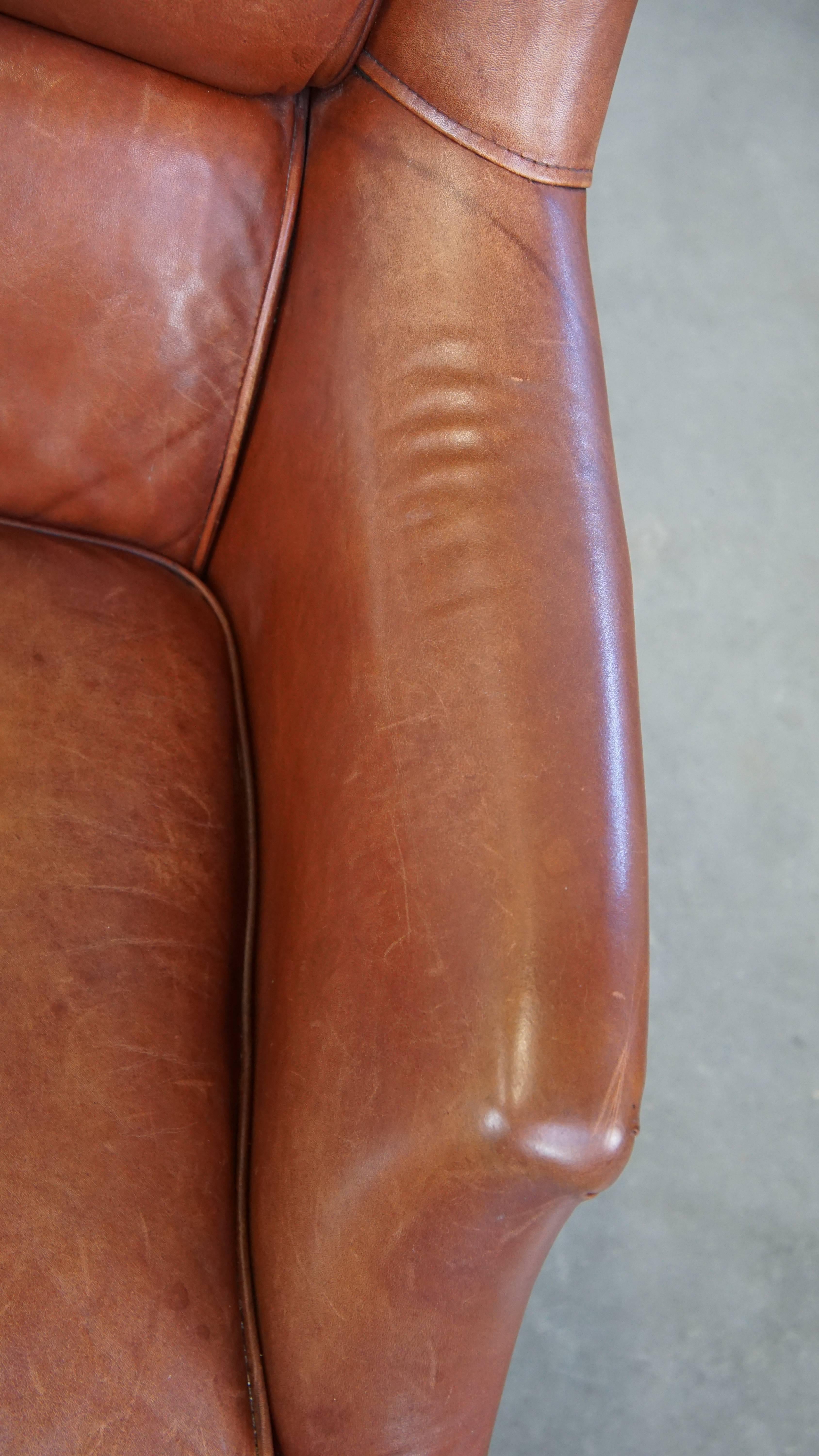 Fauteuil confortable en cuir de vache en bon état, fini avec des clous décoratifs en vente 2