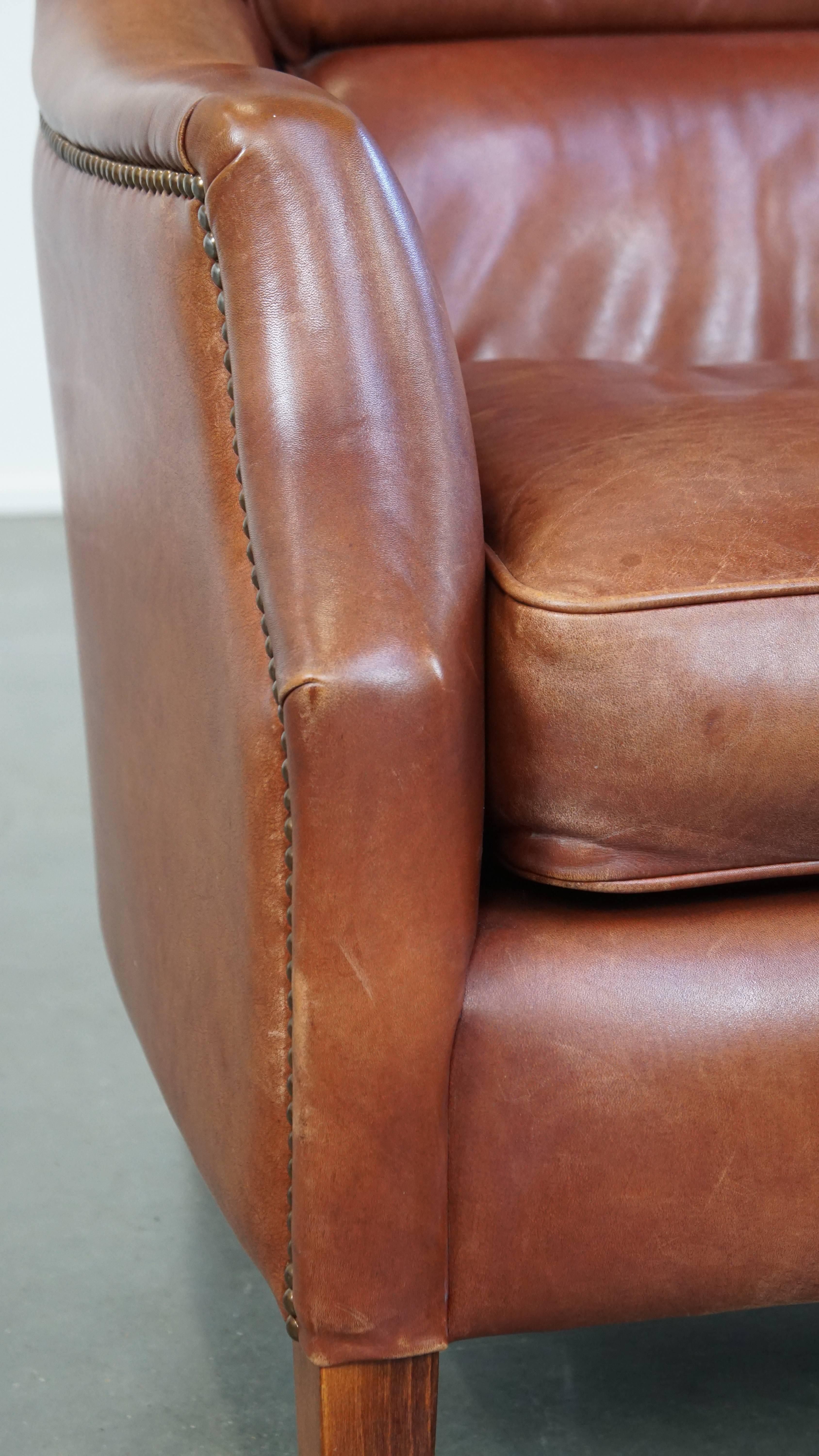 Fauteuil confortable en cuir de vache en bon état, fini avec des clous décoratifs en vente 3