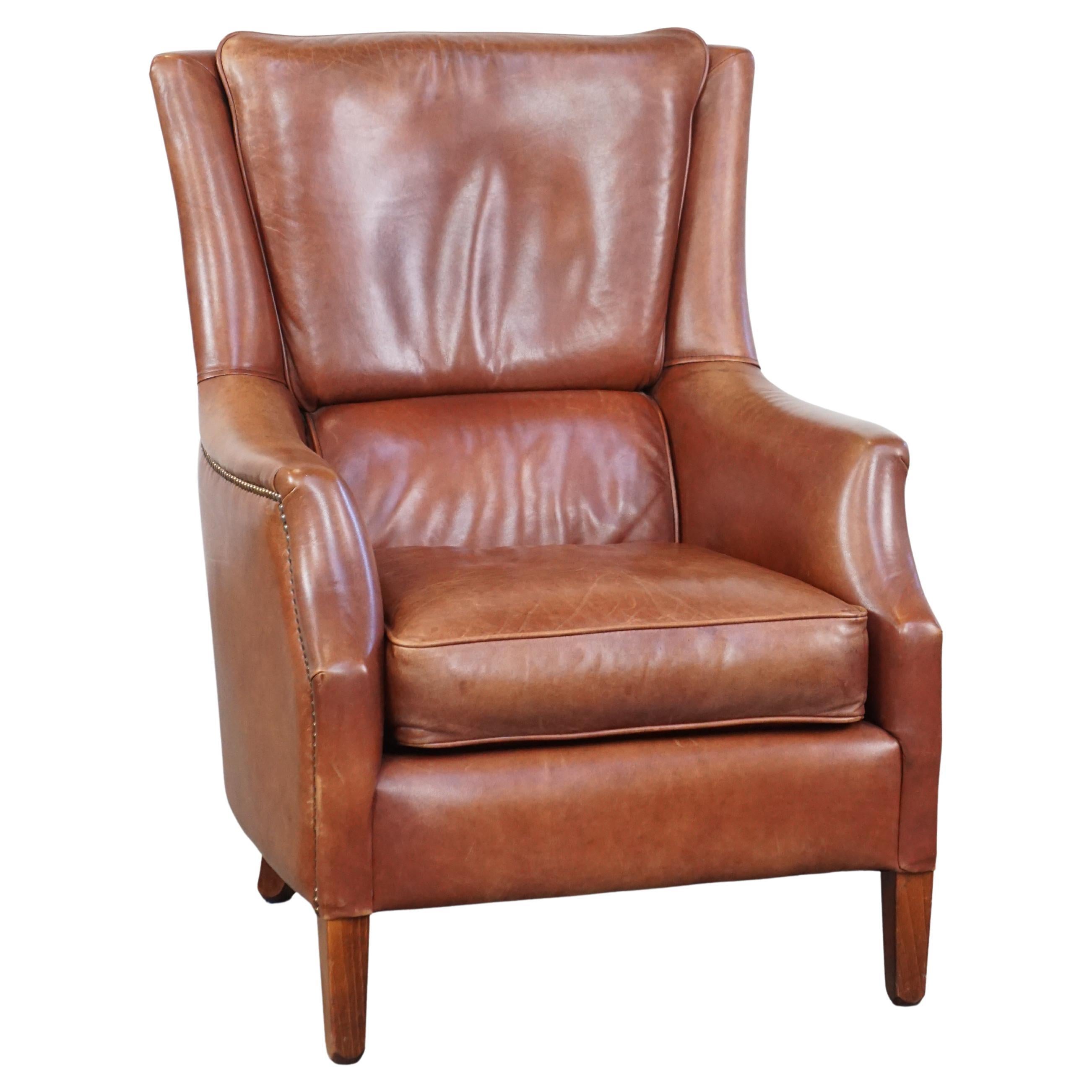 Comfortable cowhide armchair in good condition, finished with decorative nails