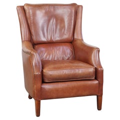 Comfortable cowhide armchair in good condition, finished with decorative nails