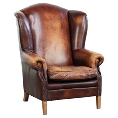 Comoda poltrona con schienale ad ali in pelle di vacchetta, in stile inglese