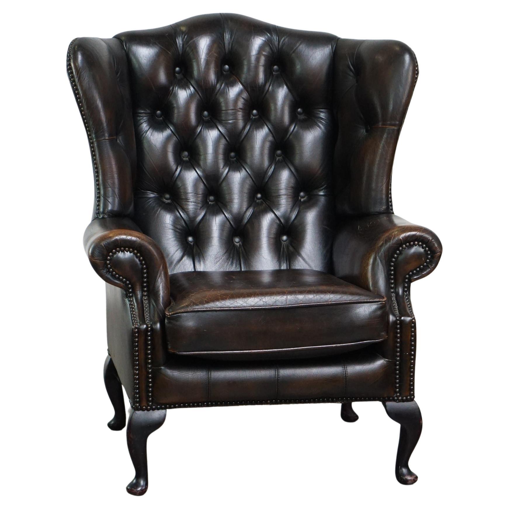 Comfortable dark brown vintage leather English chesterfield armchair