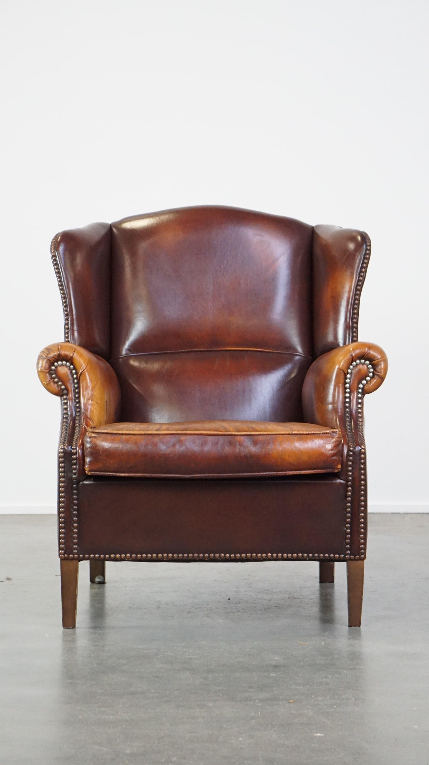 Angeboten wird dieser bequeme, elegante, stattliche Ohrensessel aus Schafsleder in einer schönen Cognacfarbe.

Dieser stilvolle Schafsledersessel hat eine schöne warme Farbe und ist mit Ziernägeln versehen, was ihm ein elegantes und stattliches