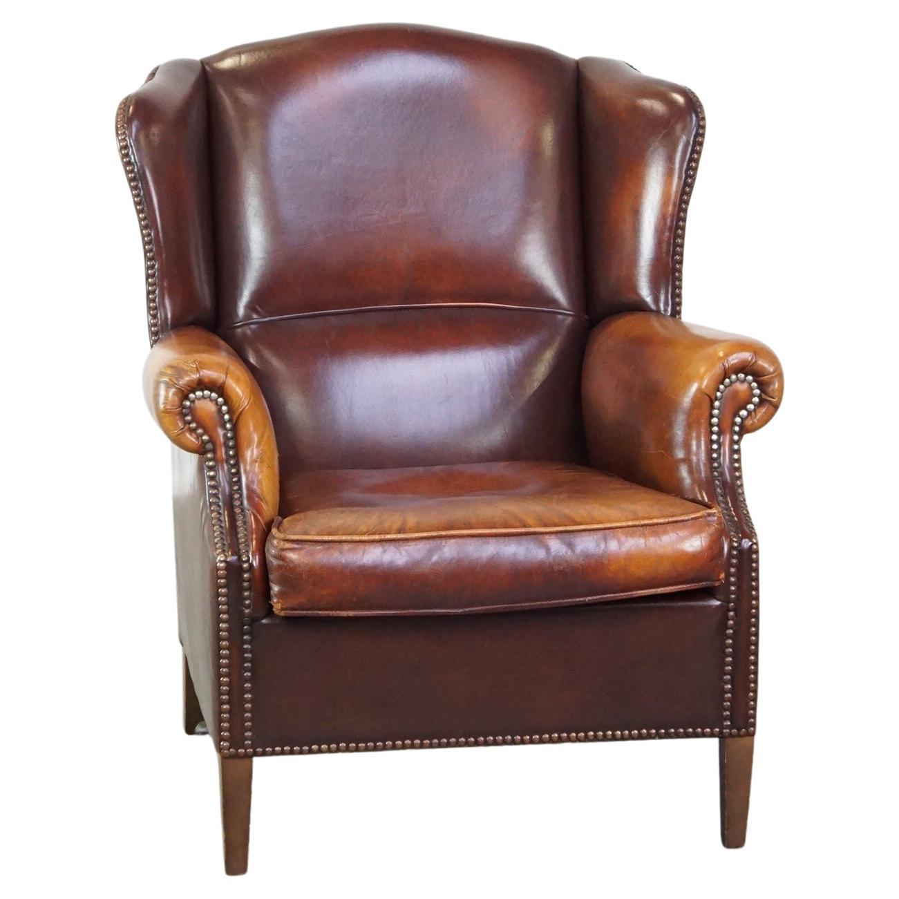 Comfortable, elegant wing chair made of sheepskin in a beautiful warm color